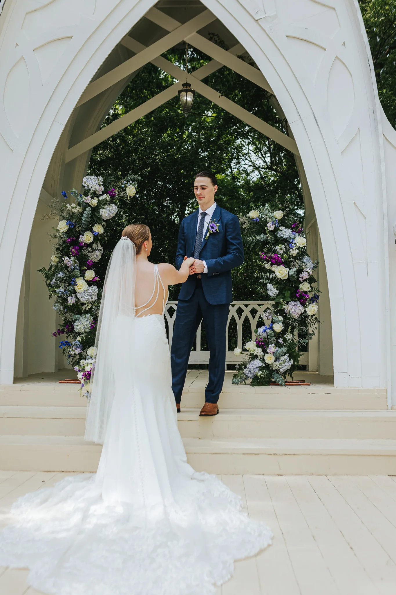 Wedding Formals: holding hands in front of the chapel arch, at their wedding at The Wildflower 301 in Greensboro, GA