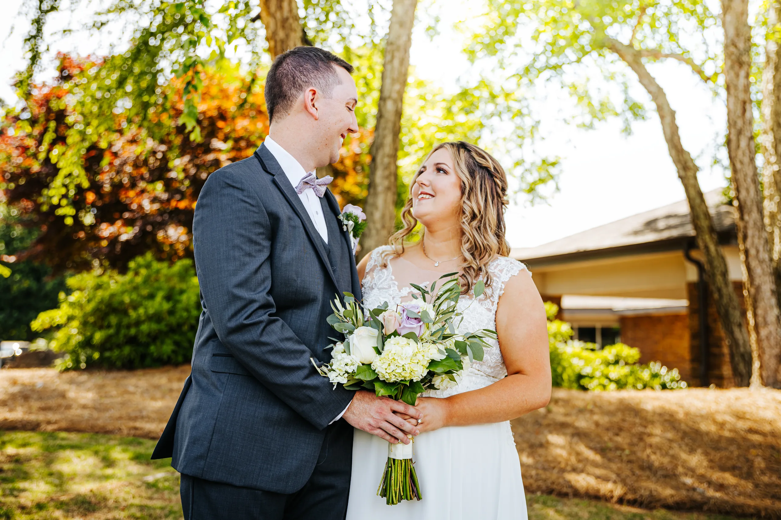 Wedding Formals: smiling at each other under the willow tree at their wedding at the Country Club of Roswell in Roswell, GA
