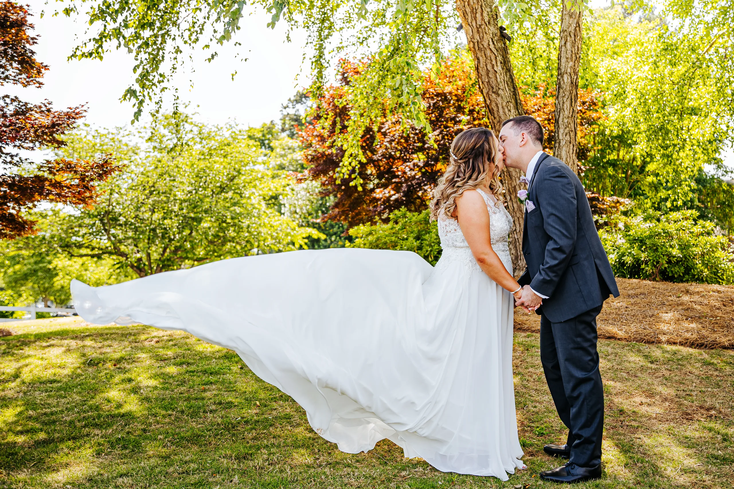 Wedding Formals: a kiss as her gown flies out behind her at their wedding at the Country Club of Roswell in Roswell, GA