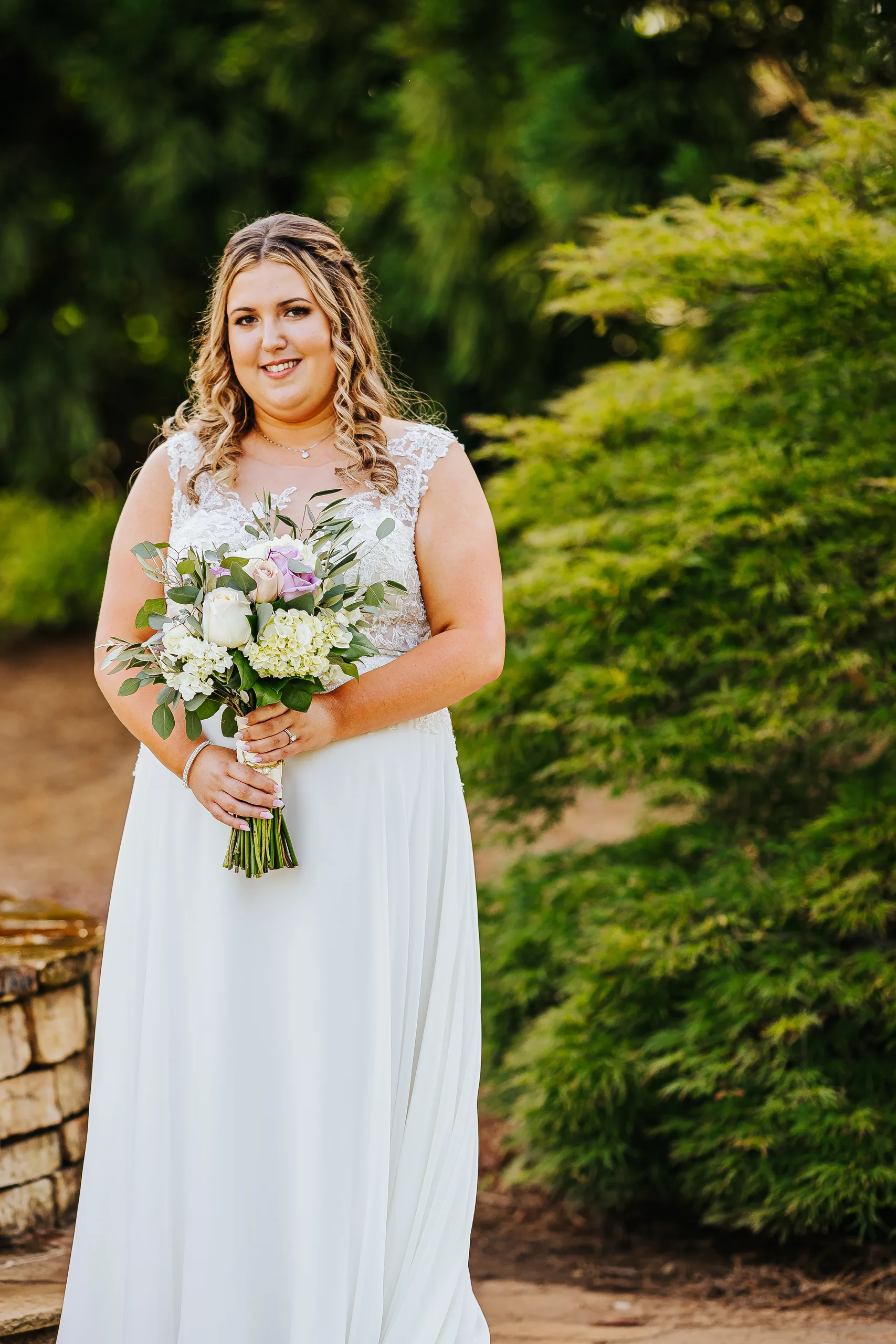 Bridal Portraits: the bride with her bouquet in the garden at their wedding at the Country Club of Roswell in Roswell, GA