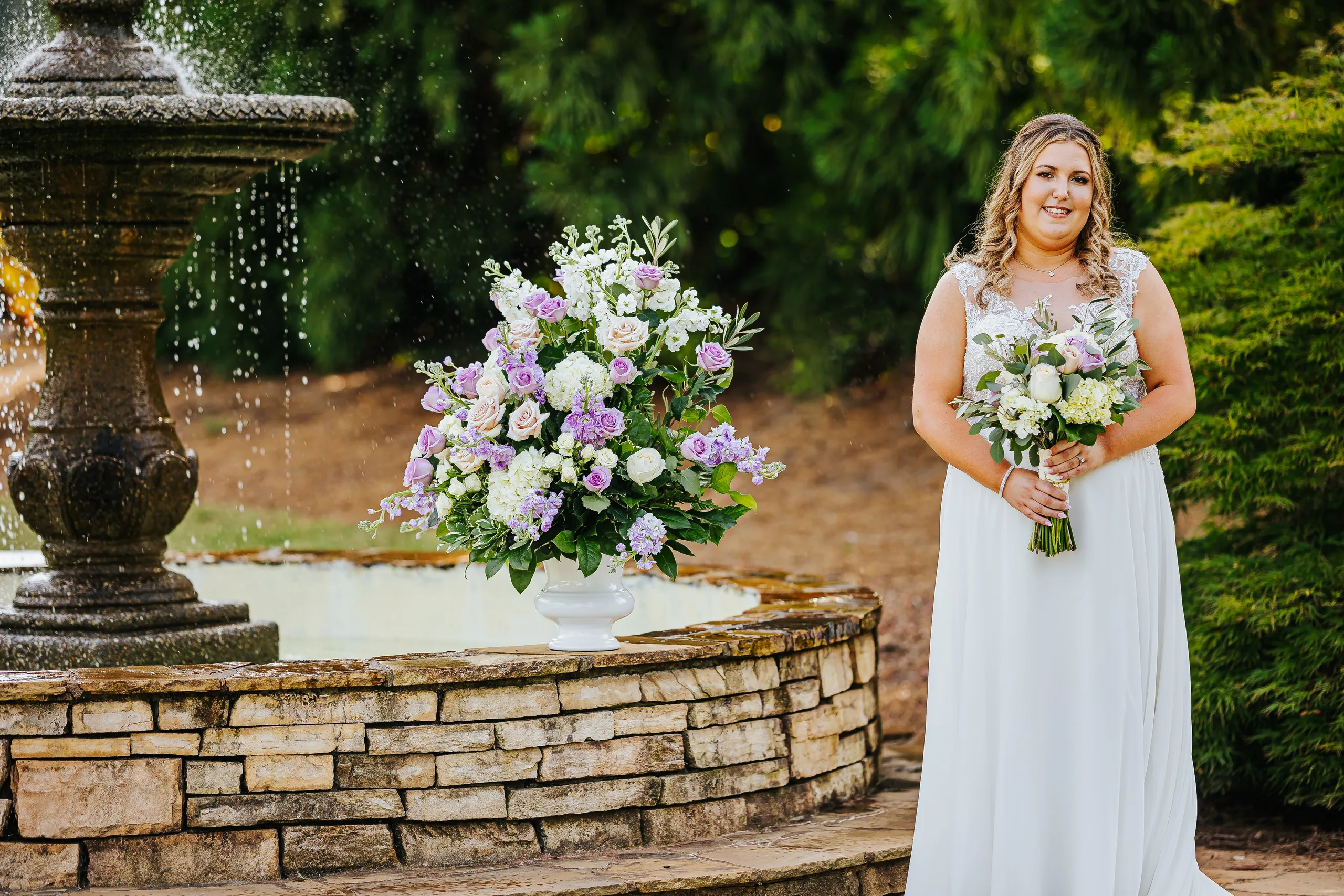 Bridal Portraits: the bride beside the fountain and flowers at their wedding at the Country Club of Roswell in Roswell, GA