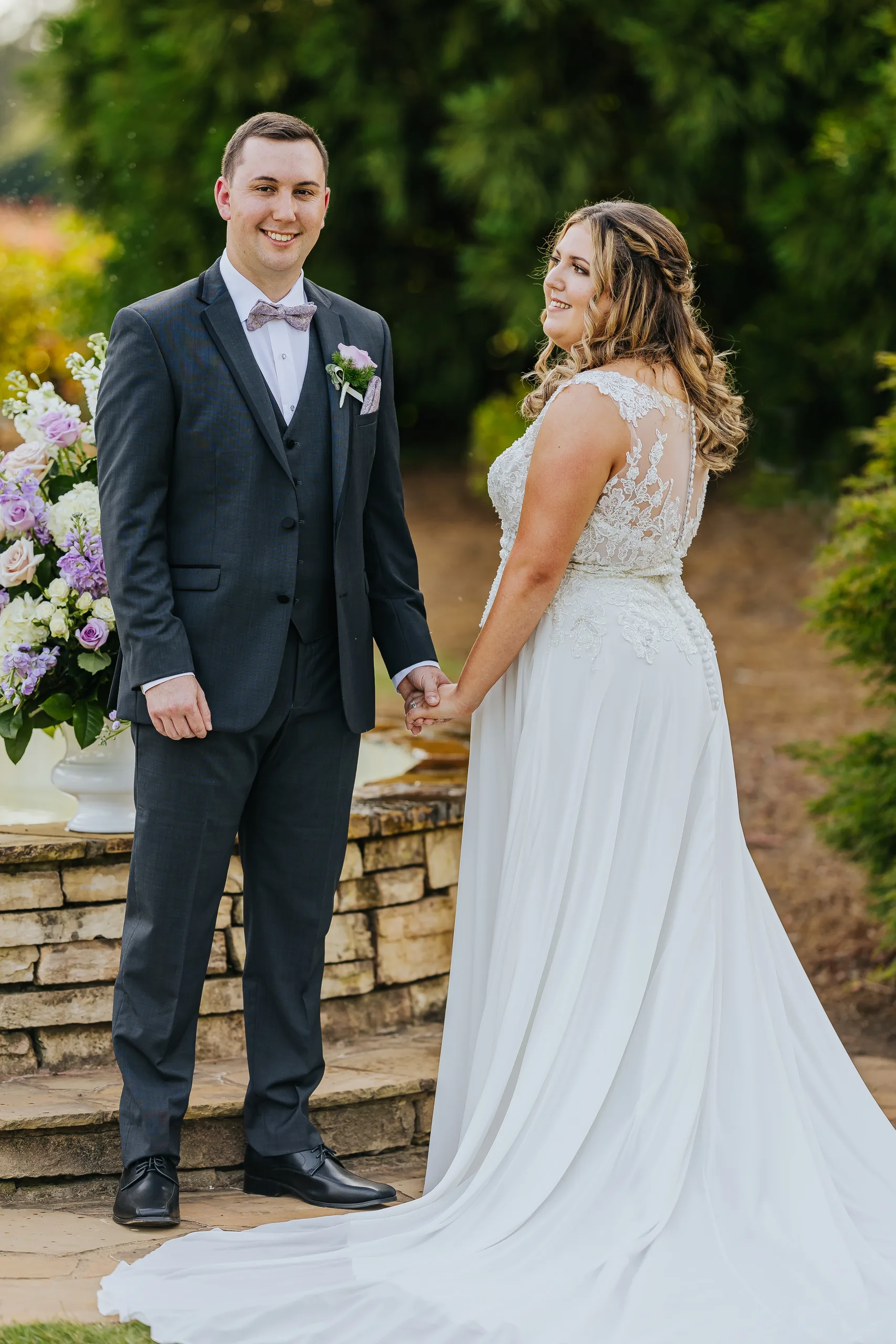 Wedding Formals: holding hands by the fountain at their wedding at the Country Club of Roswell in Roswell, GA