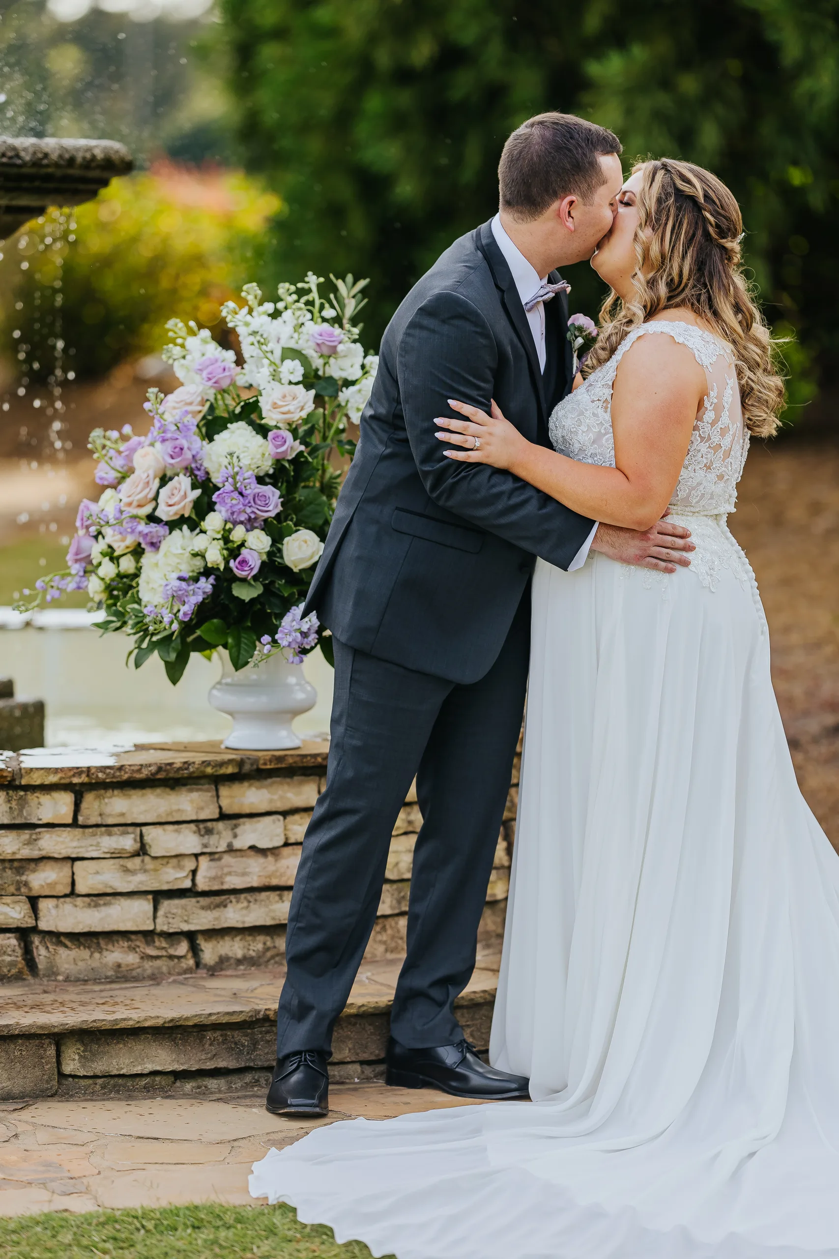 Wedding Formals: a kiss beside the fountain at their wedding at the Country Club of Roswell in Roswell, GA