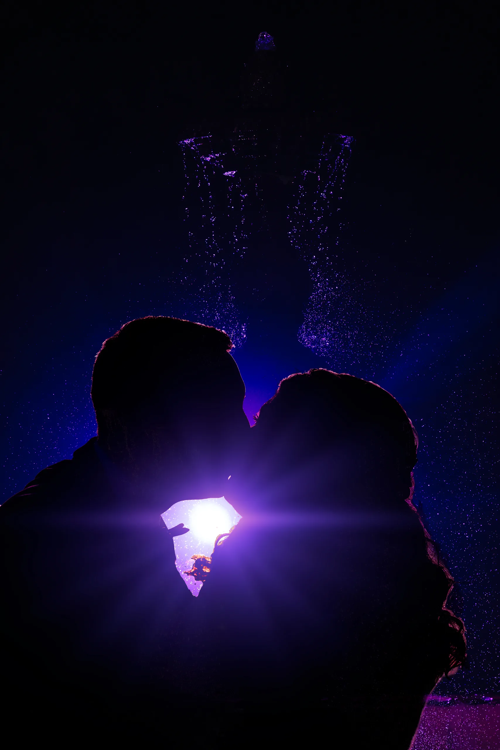 Wedding Formals: a kiss in silhouette at the fountain at night at their wedding at the Country Club of Roswell in Roswell, GA