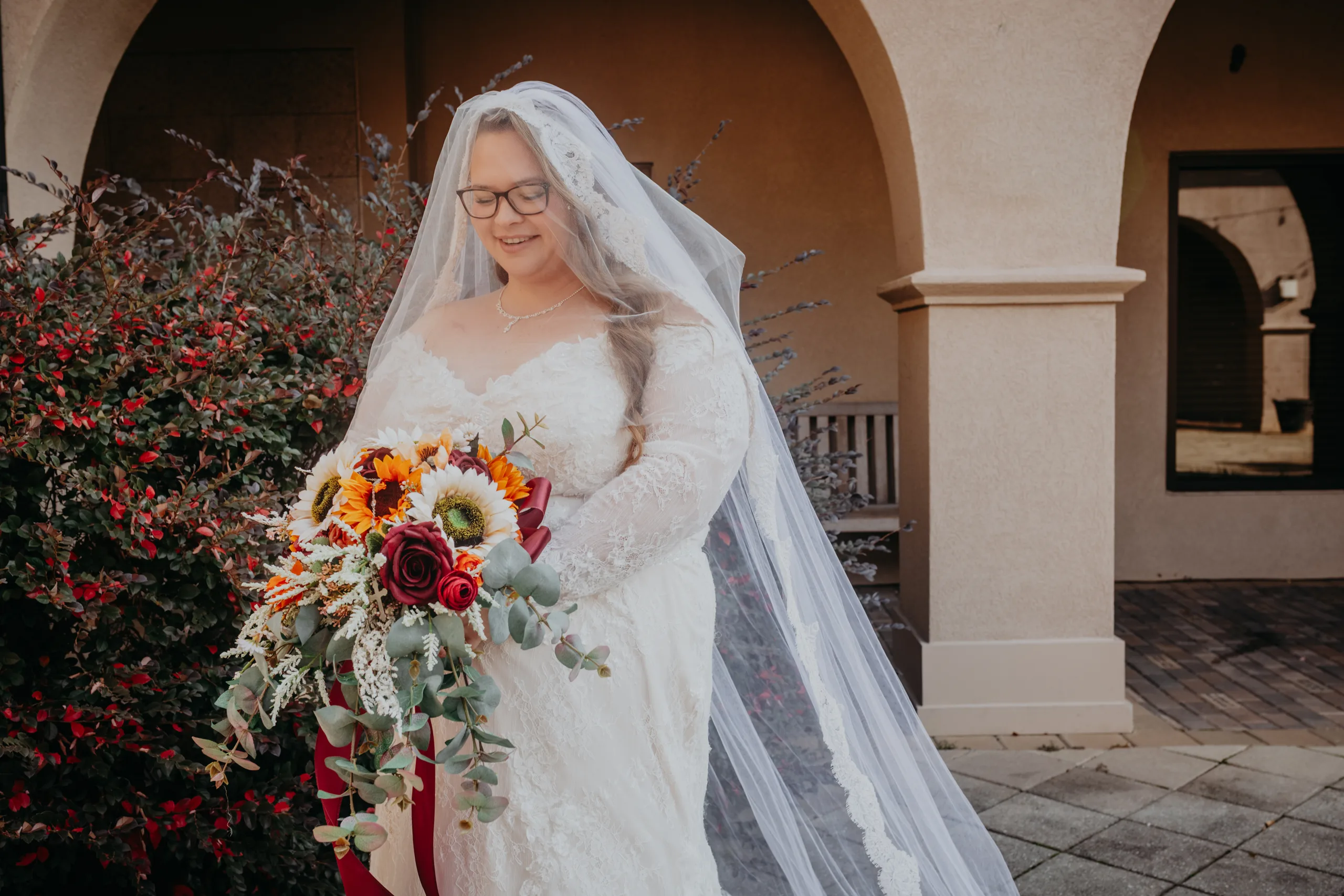Bridal Portraits: the bride under the courtyard arches in her cathedral veil, at their wedding at St. Lawrence Catholic Church in Lawrenceville, GA