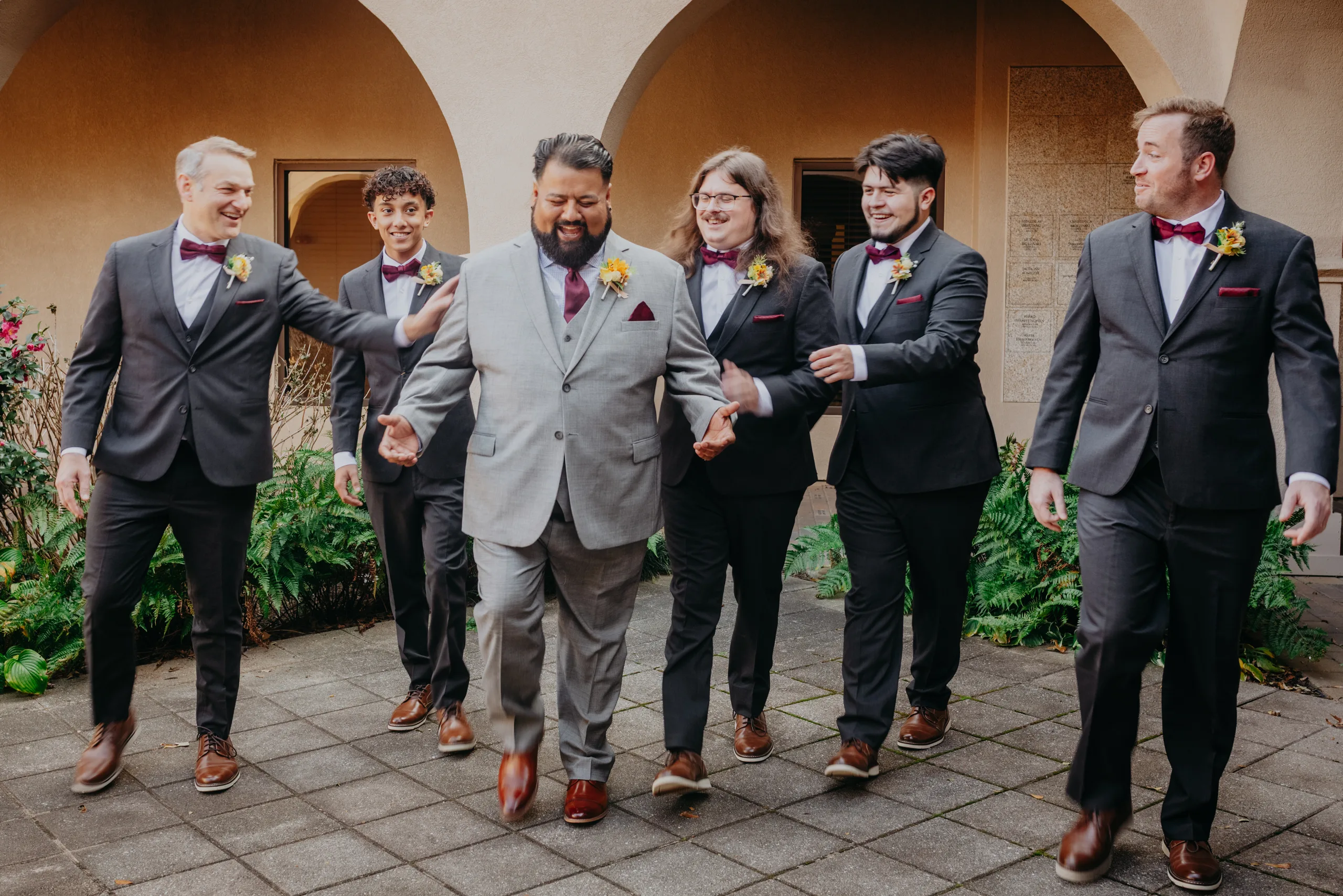 Wedding Party: the groom and his groomsmen walking through the courtyard, at their wedding at St. Lawrence Catholic Church in Lawrenceville, GA