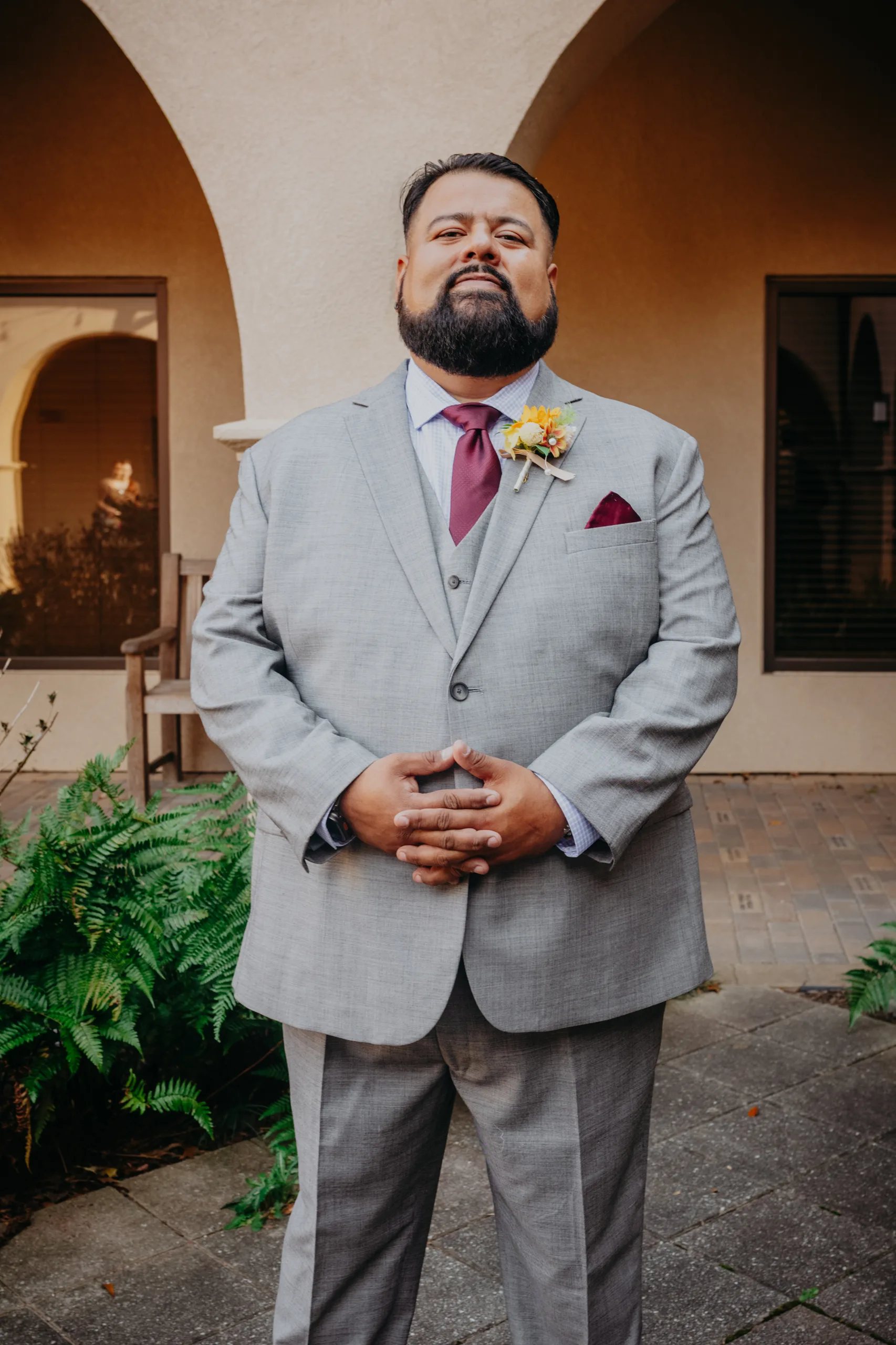 Wedding Formals: the groom in his grey suit in the courtyard, at their wedding at St. Lawrence Catholic Church in Lawrenceville, GA
