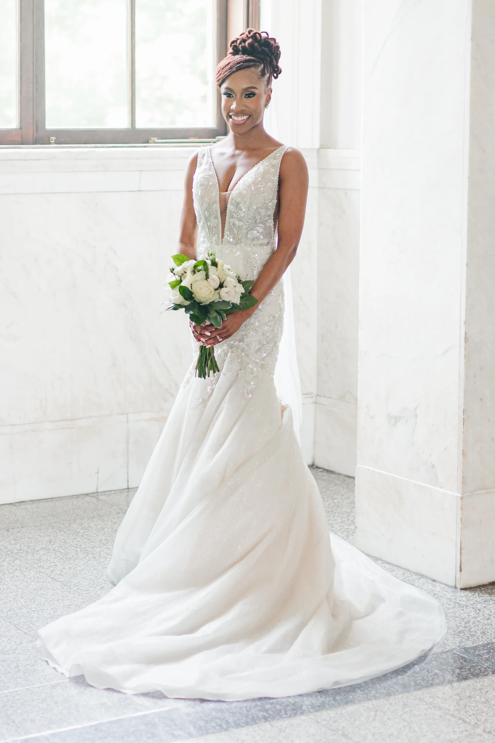 Bridal Portraits: the bride with her bouquet on the terrazzo floor, at their wedding at the Historic DeKalb Courthouse in Decatur, GA