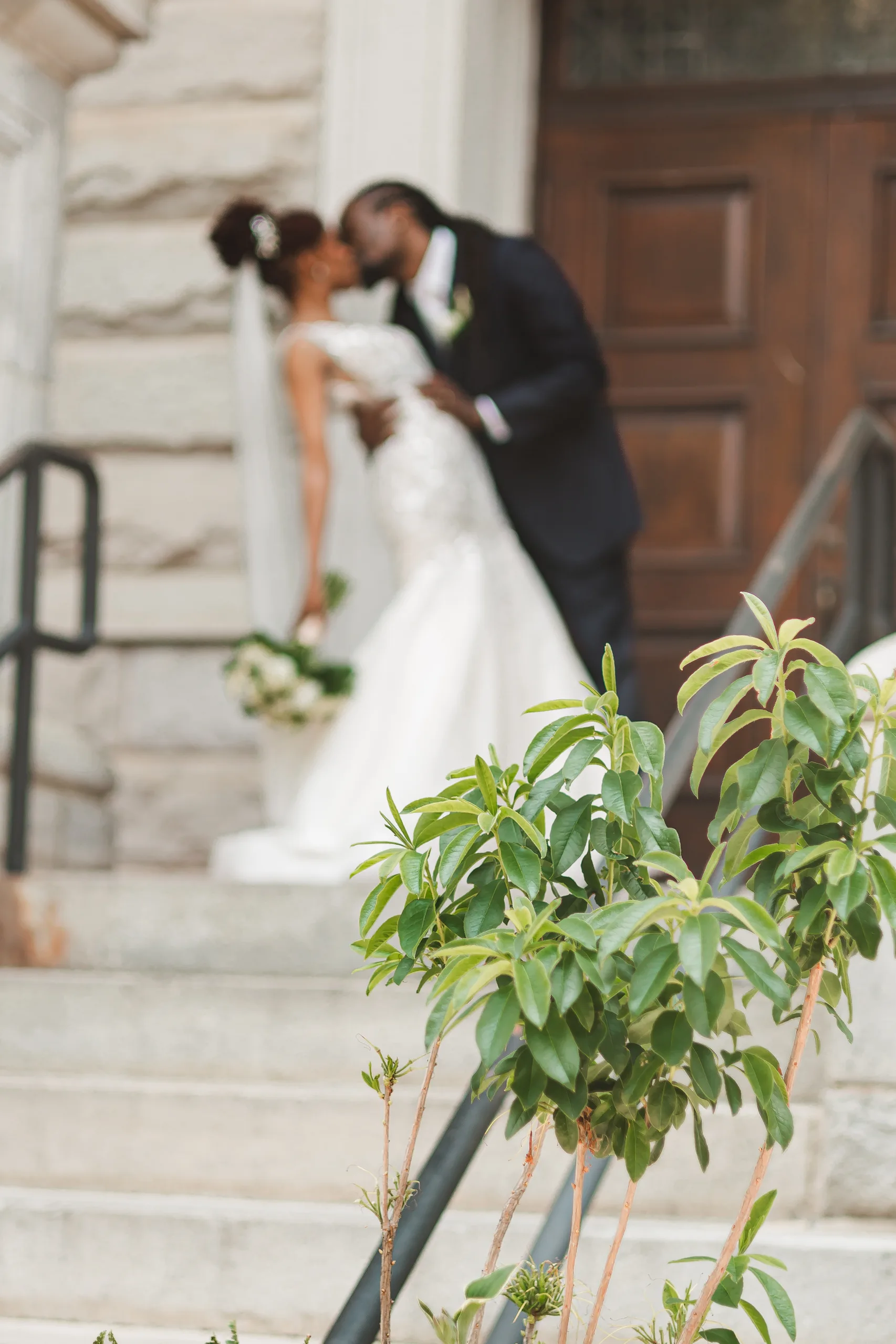 Wedding Formals: a kiss on the front steps, at their wedding at the Historic DeKalb Courthouse in Decatur, GA