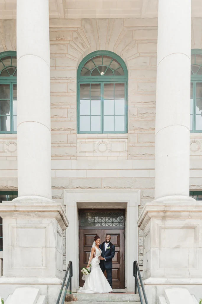 Wedding Formals: the two of them at the front doors between the columns, at their wedding at the Historic DeKalb Courthouse in Decatur, GA