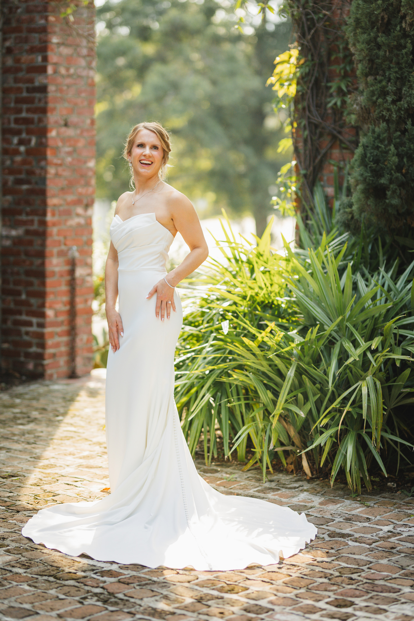 Bridal Portraits: the bride and her chapel train on the cobblestones by the brick wall, at her wedding at Summerour Studio in Atlanta, GA