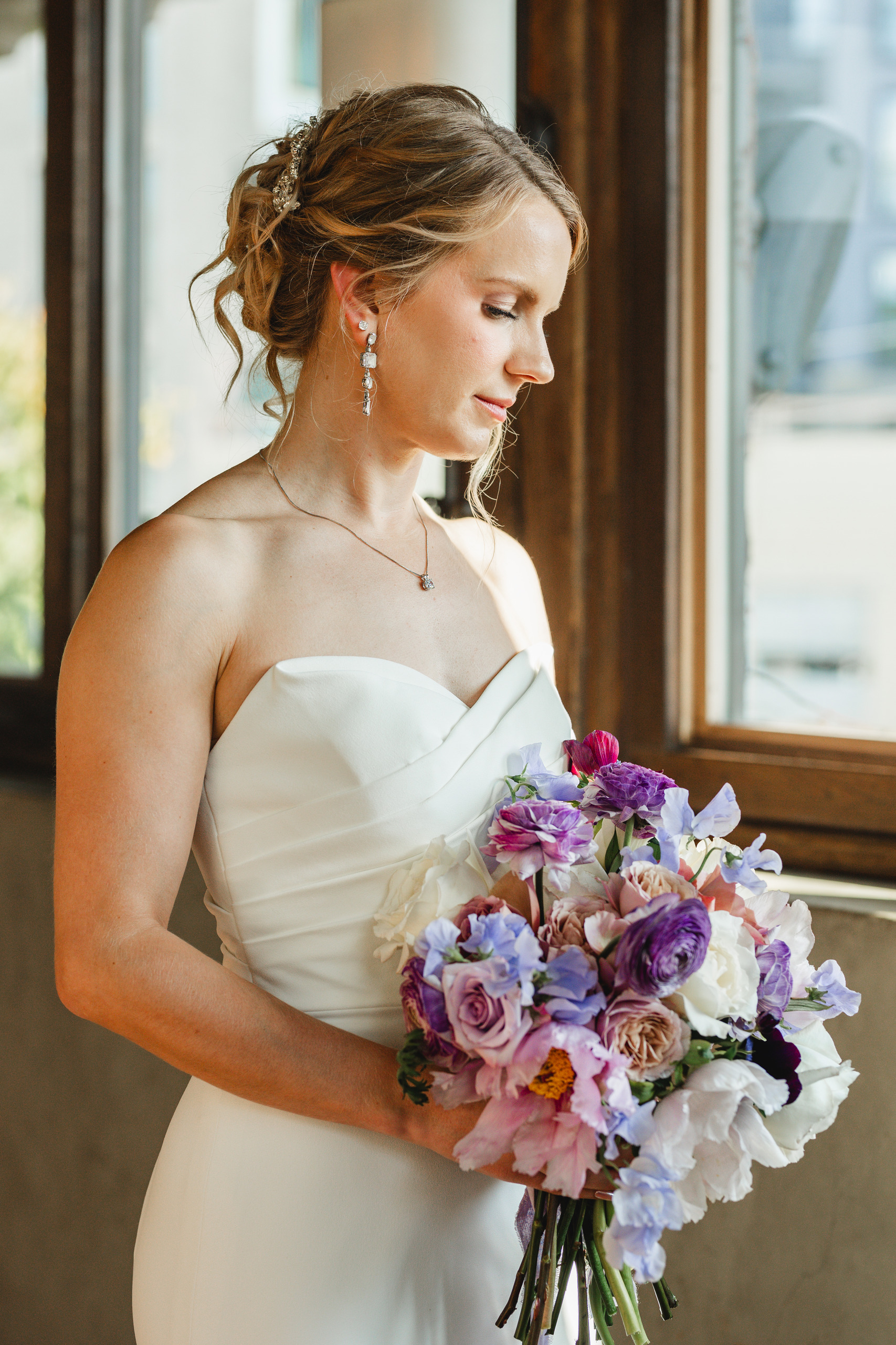 Bridal Portraits: the bride with her bouquet in the window light, at her wedding at Summerour Studio in Atlanta, GA