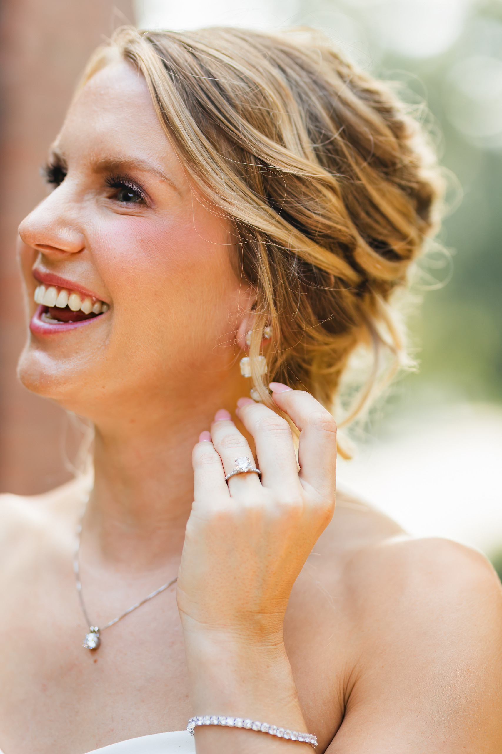 Bridal Portraits: the bride laughing, her hand at her earring, at her wedding at Summerour Studio in Atlanta, GA