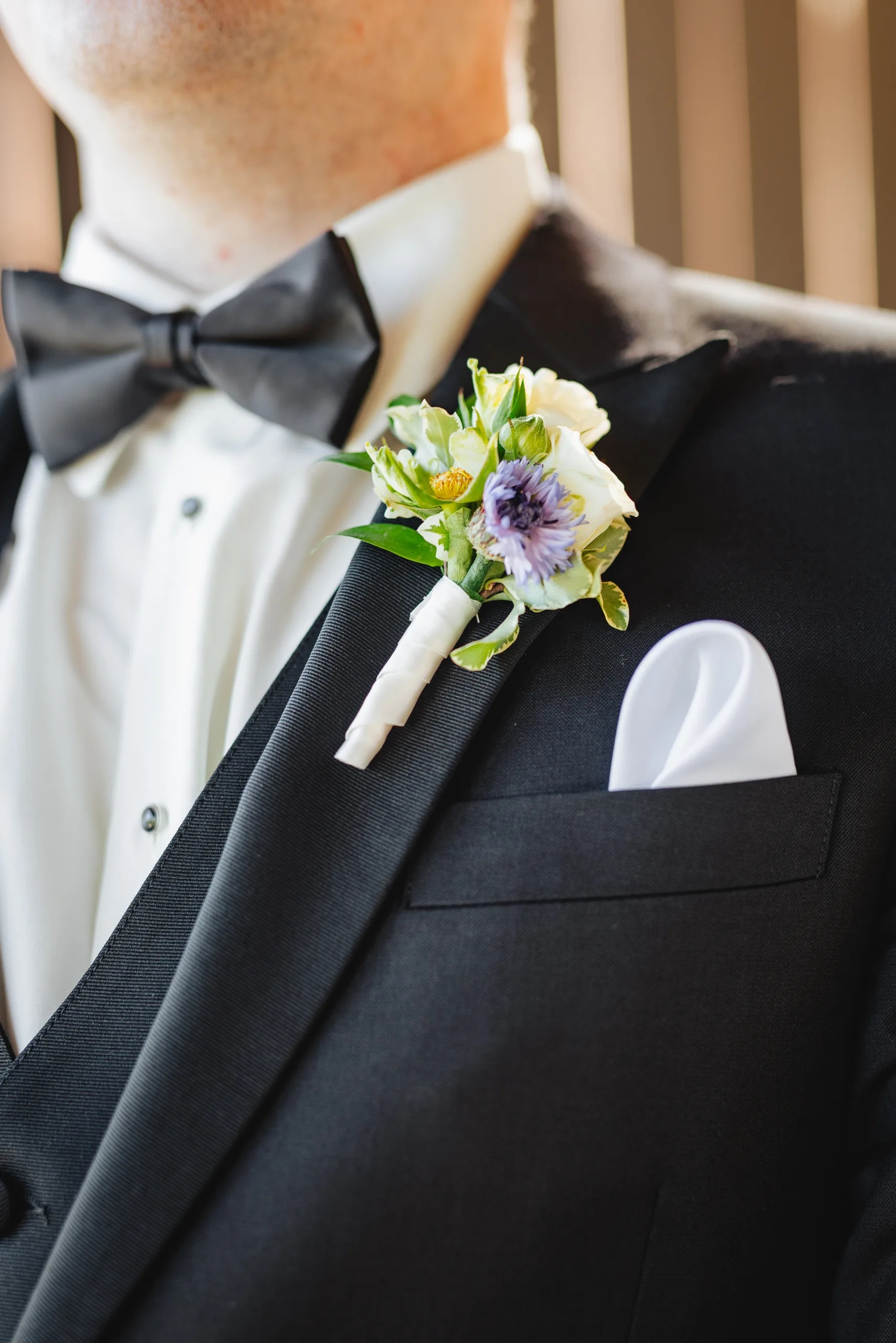 Wedding Details: his boutonniere and white pocket square at a wedding at Ivy Hall at Roswell Mill in Roswell, GA