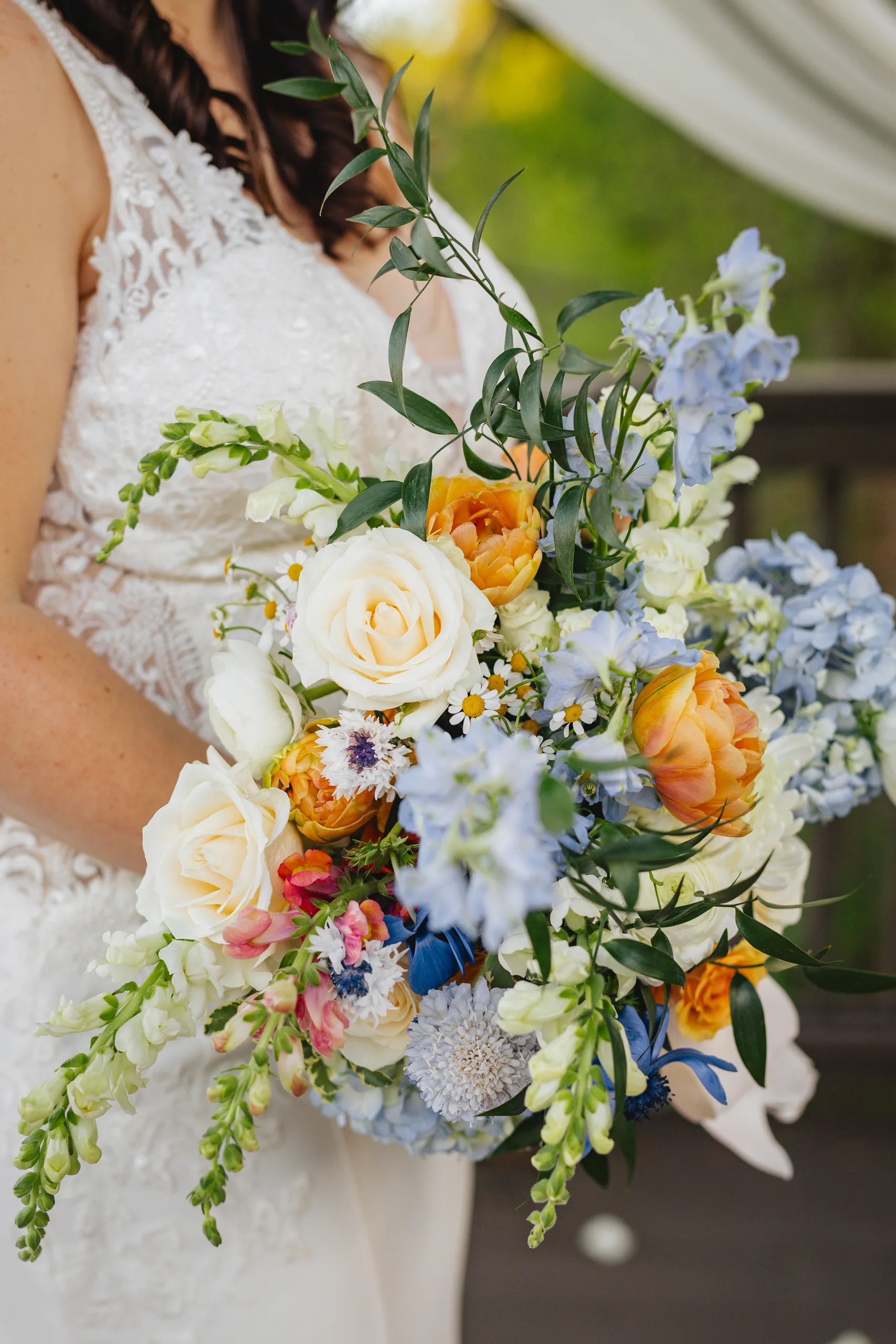 Wedding Florals: her bouquet of white and peach roses with blue flowers at a wedding at Ivy Hall at Roswell Mill in Roswell, GA