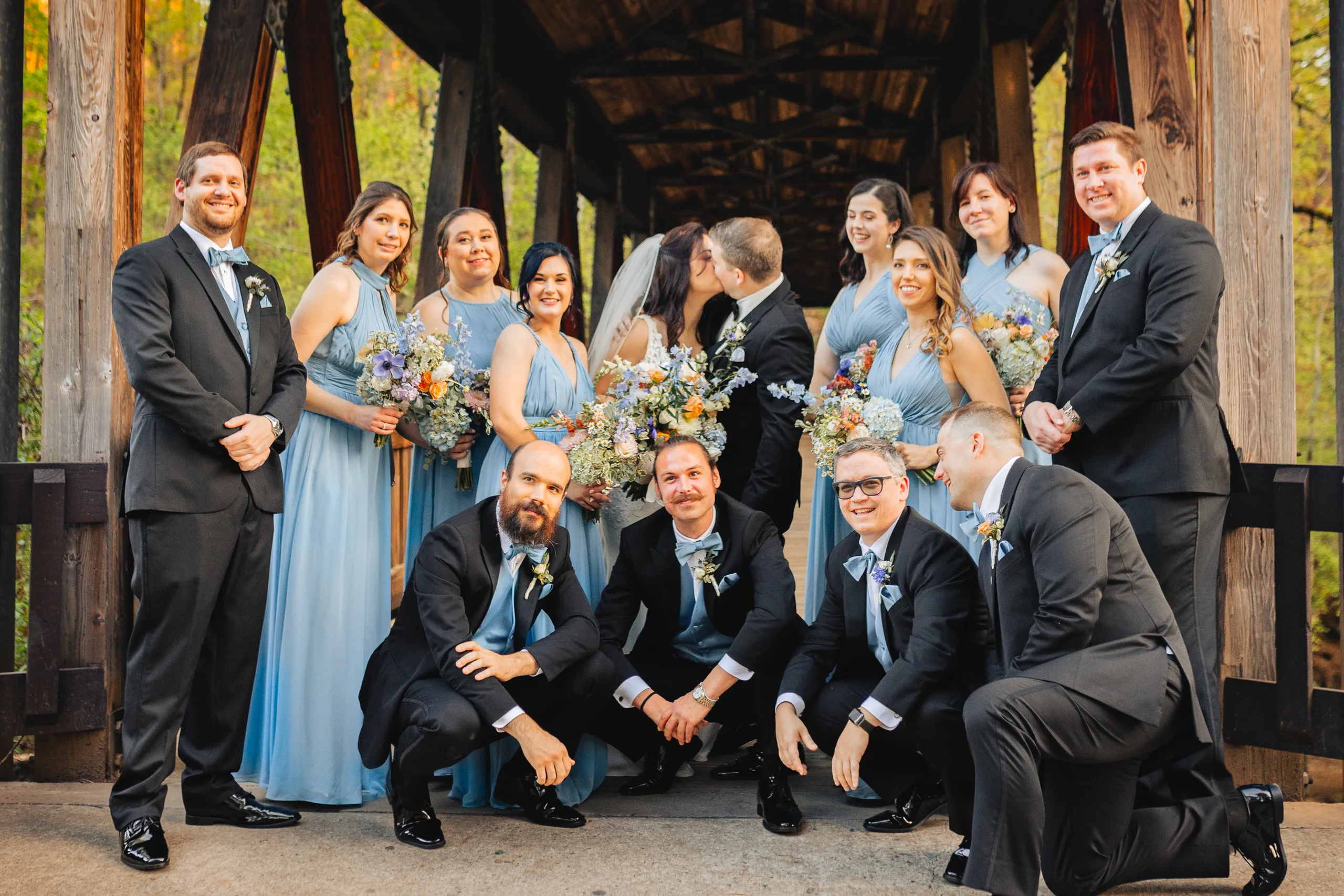Wedding Party: the whole wedding party on the covered bridge at their wedding at Ivy Hall at Roswell Mill in Roswell, GA