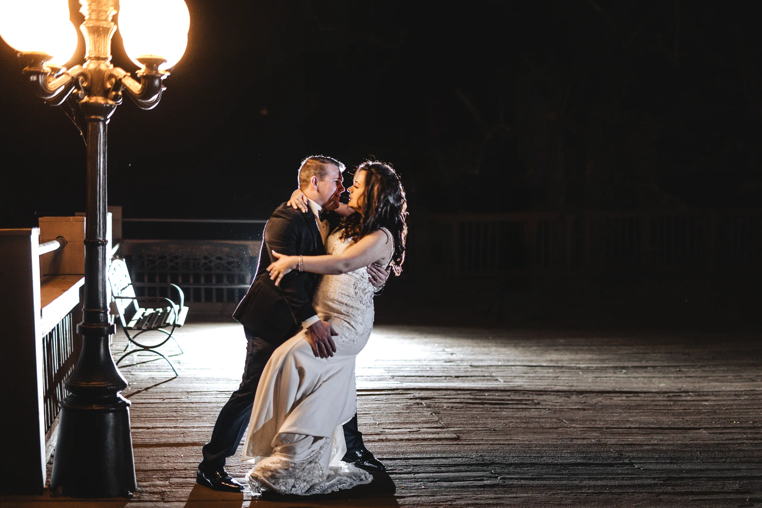 Wedding Formals: an embrace under a lamp post at night at their wedding at Ivy Hall at Roswell Mill in Roswell, GA