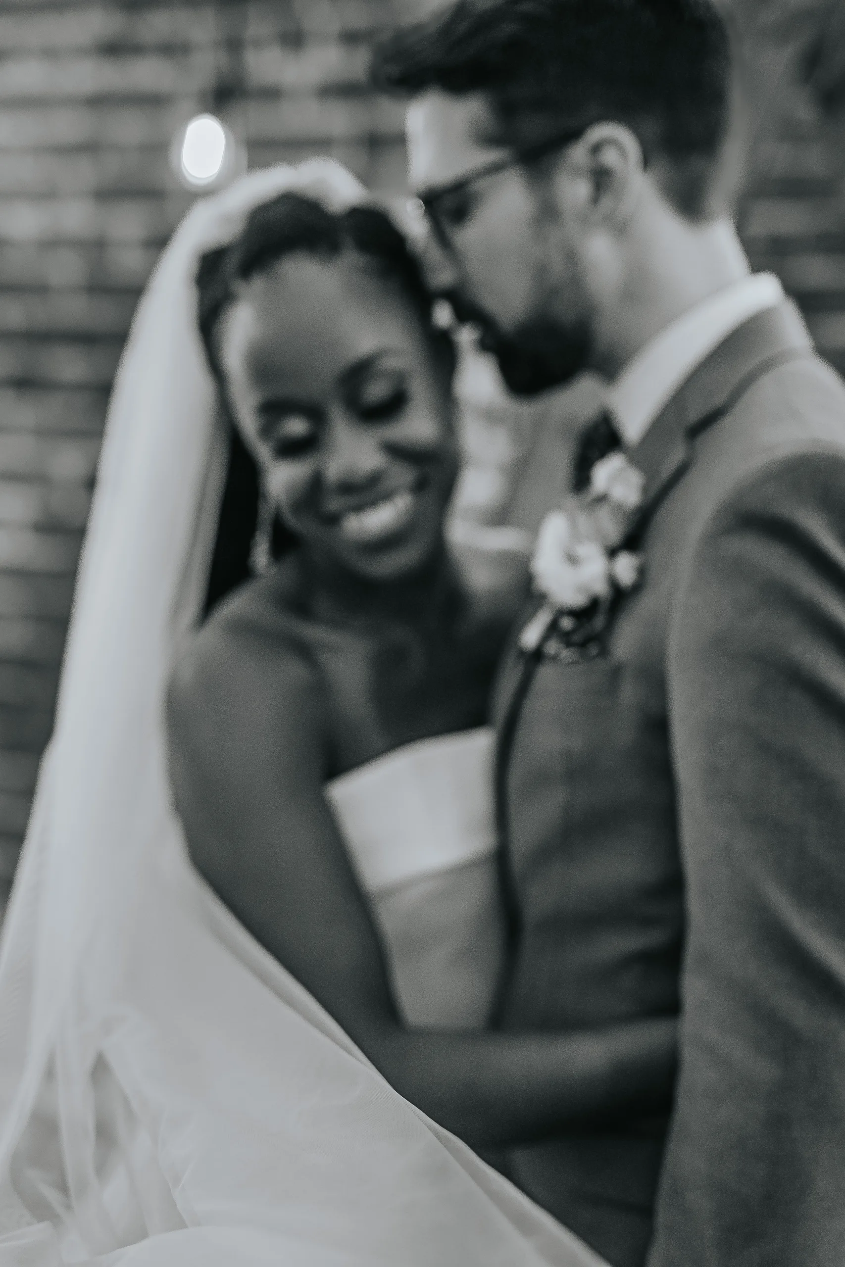 Wedding Formals: a kiss on her forehead under the veil, in black and white, at their wedding at Terminus 330 in Atlanta, GA
