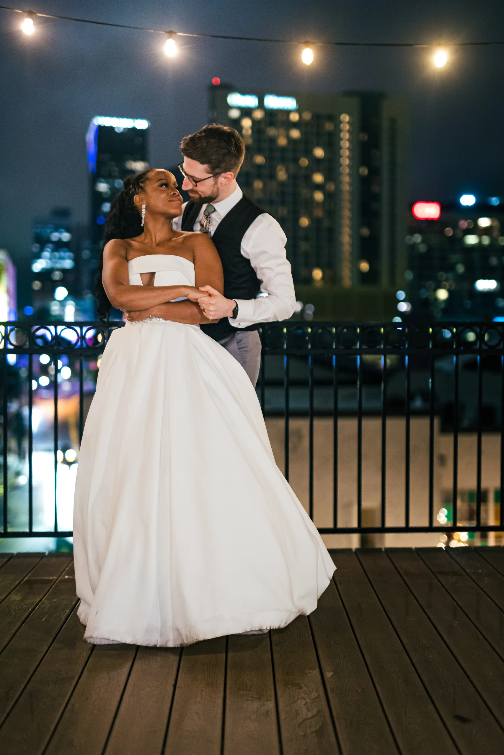 Wedding Formals: an embrace on the rooftop at night with the skyline lit up, at their wedding at Terminus 330 in Atlanta, GA