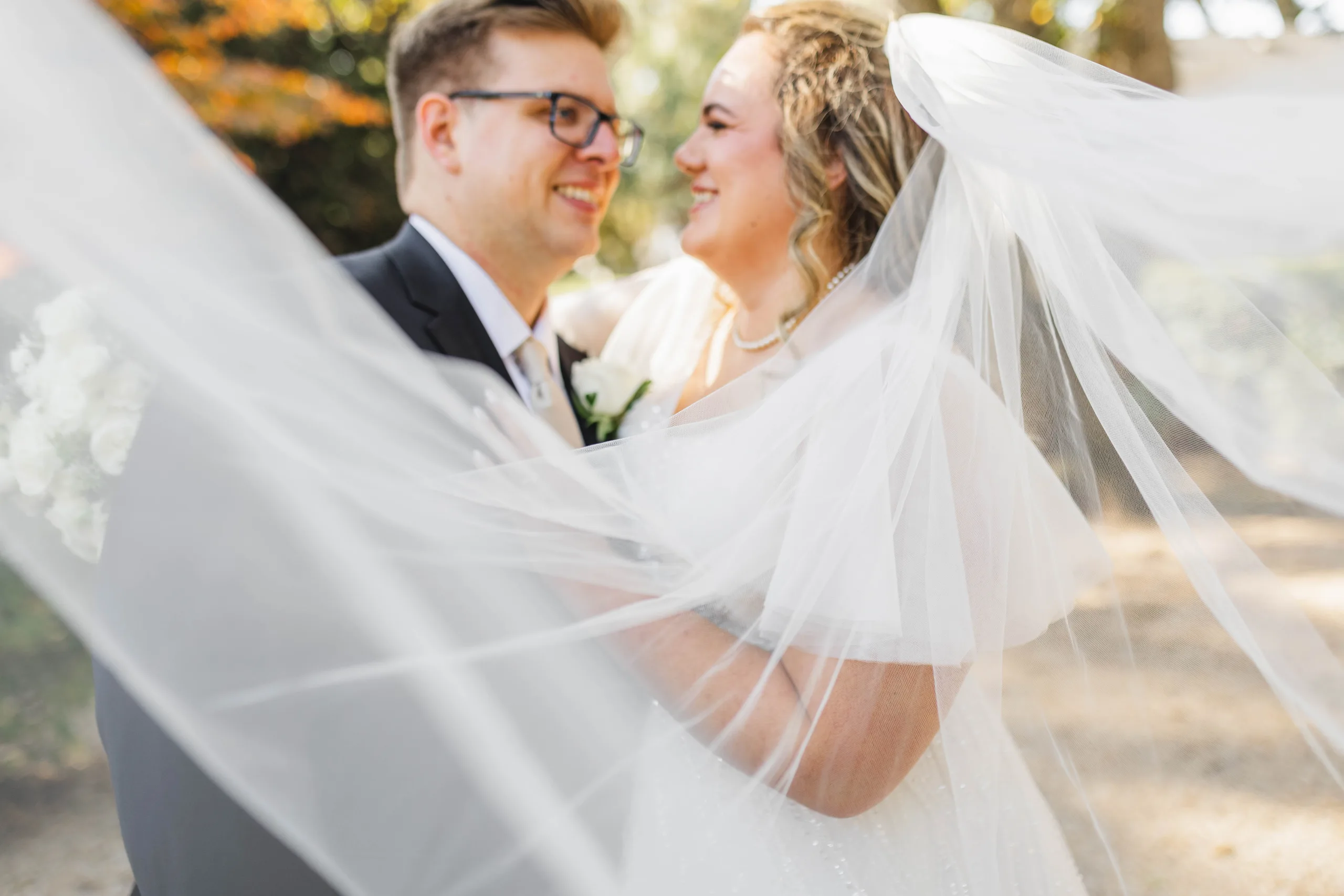 Wedding Formals: her veil blowing around them both, at their wedding at Naylor Hall in Roswell, GA