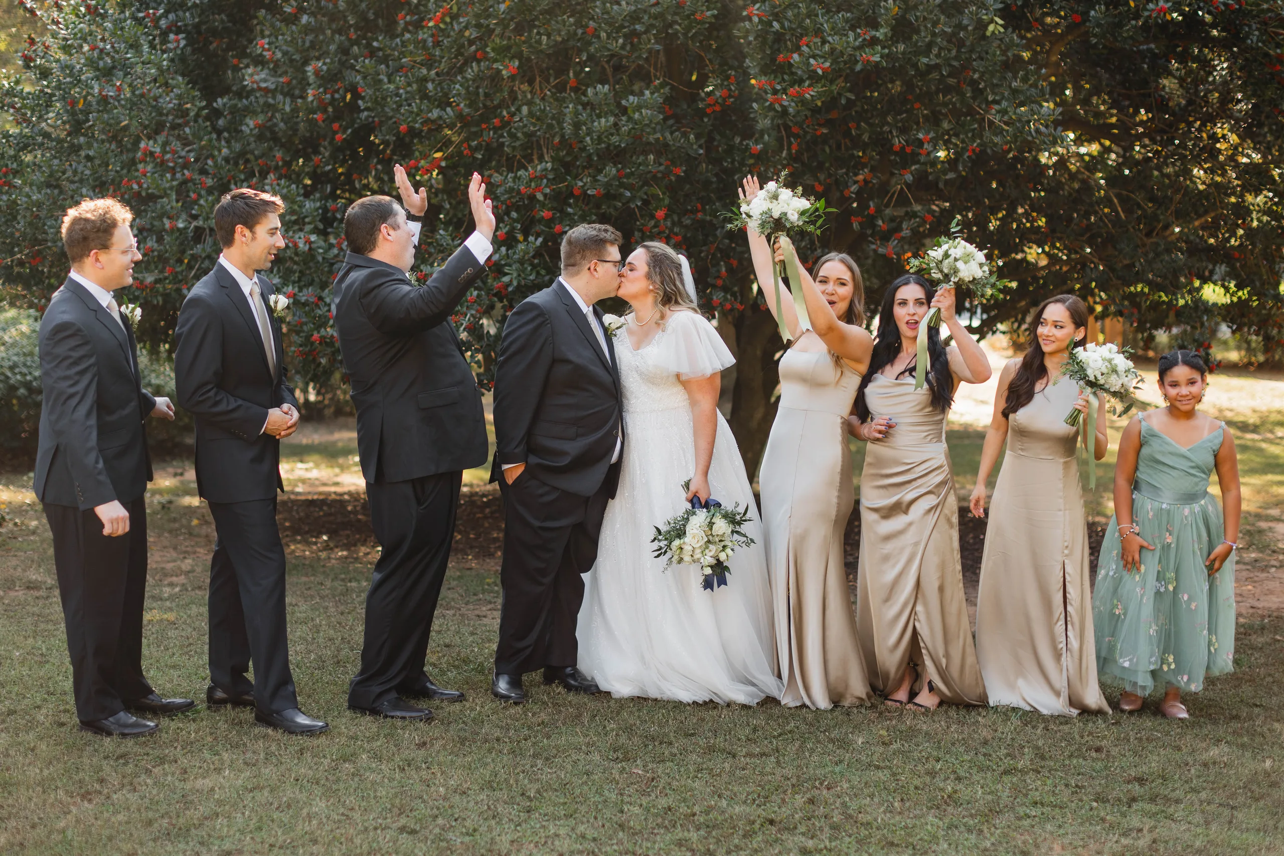 Wedding Party: a kiss as the wedding party cheers, at their wedding at Naylor Hall in Roswell, GA