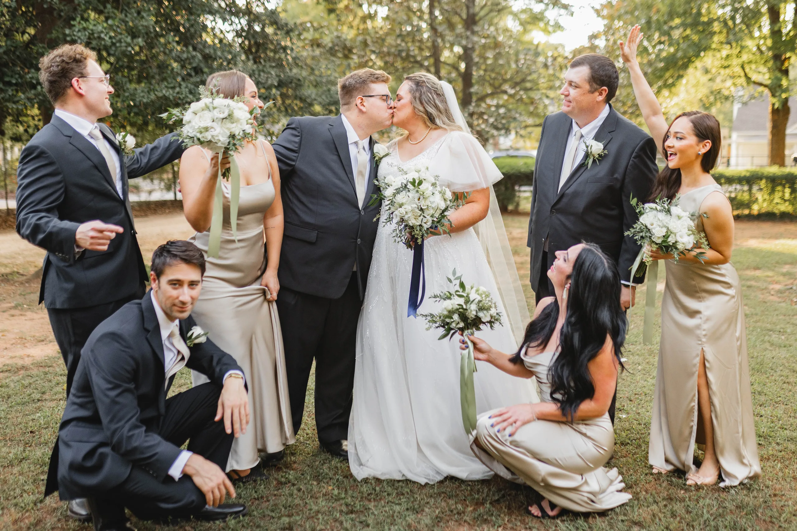 Wedding Party: a kiss in the middle of the wedding party, at their wedding at Naylor Hall in Roswell, GA
