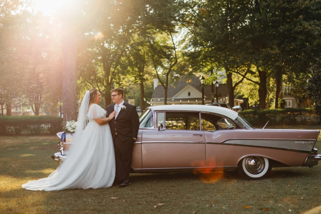 Wedding Formals: leaning against the pink Chevrolet in the late sun, at their wedding at Naylor Hall in Roswell, GA