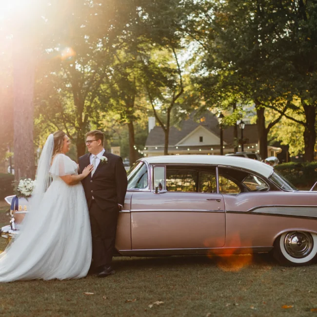 Wedding Formals: leaning against the pink Chevrolet in the late sun, at their wedding at Naylor Hall in Roswell, GA