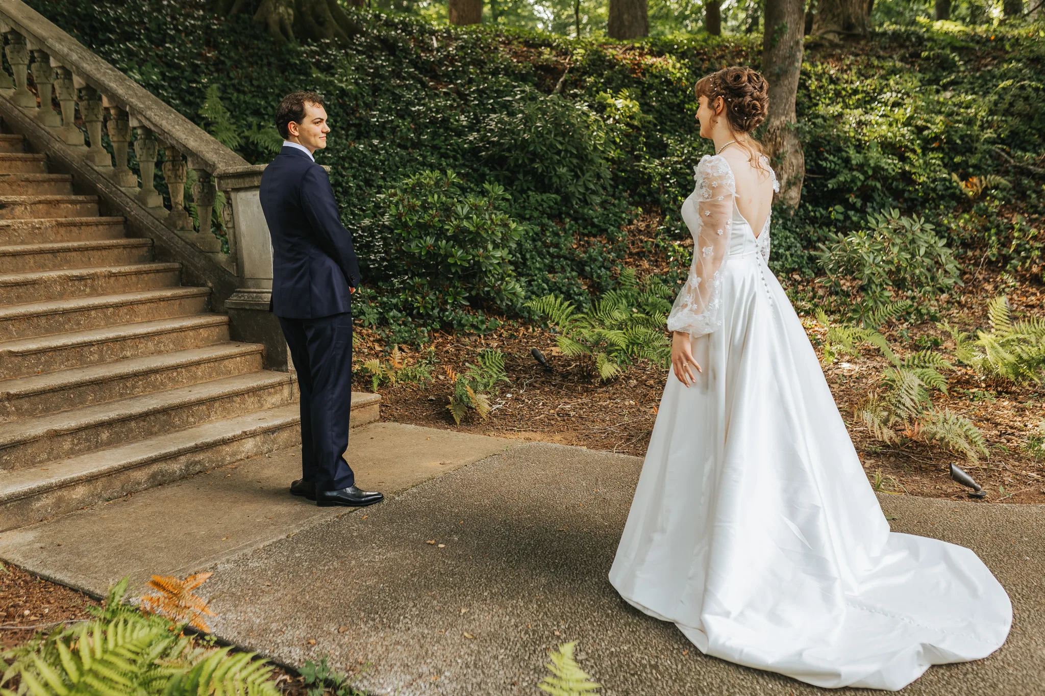 First Look: the groom waiting with his back turned in the garden, on their wedding day at Cator Woolford Gardens in Atlanta, GA