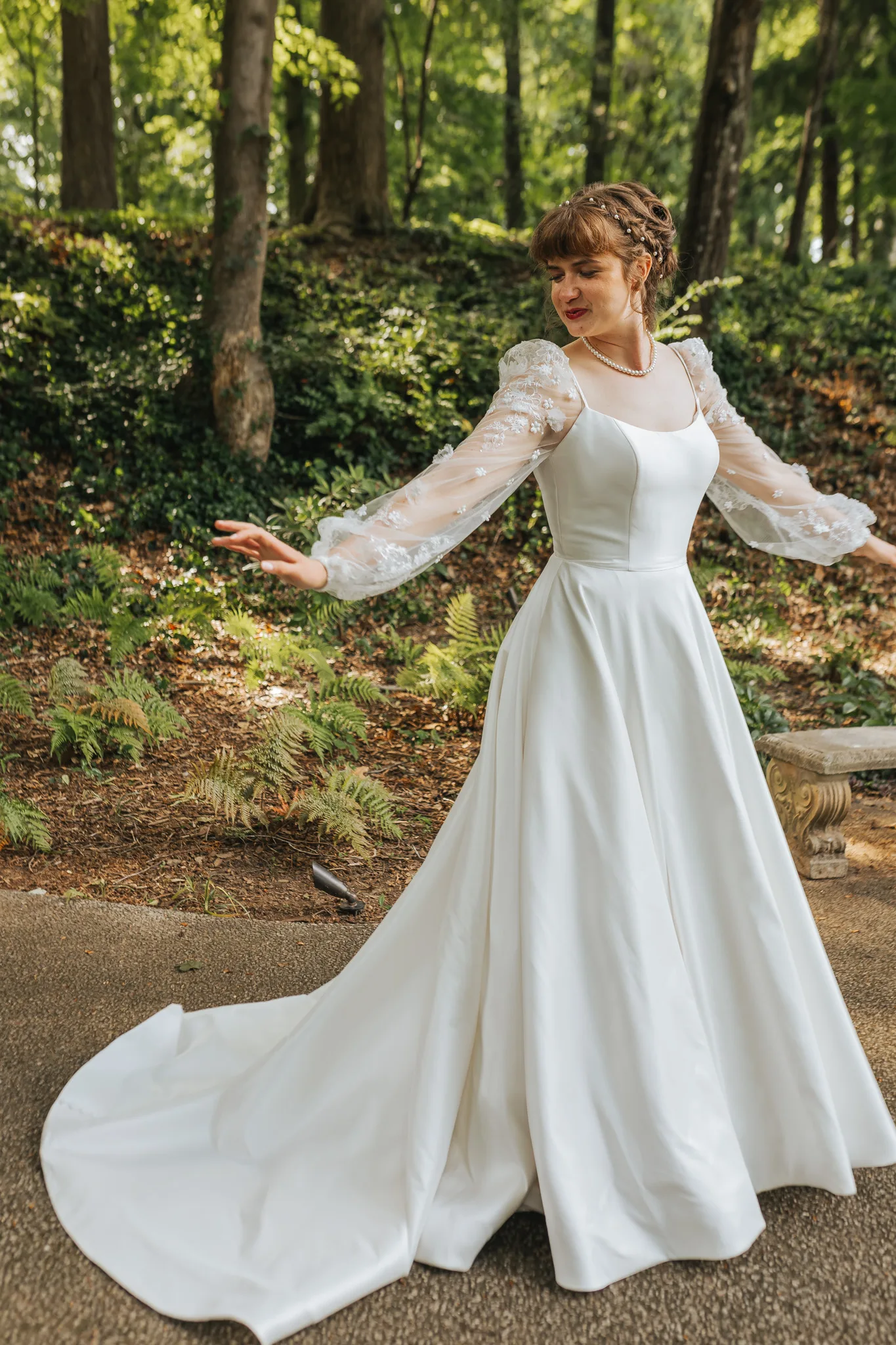 Bridal Portraits: the bride twirling in her gown in the woods, on their wedding day at Cator Woolford Gardens in Atlanta, GA