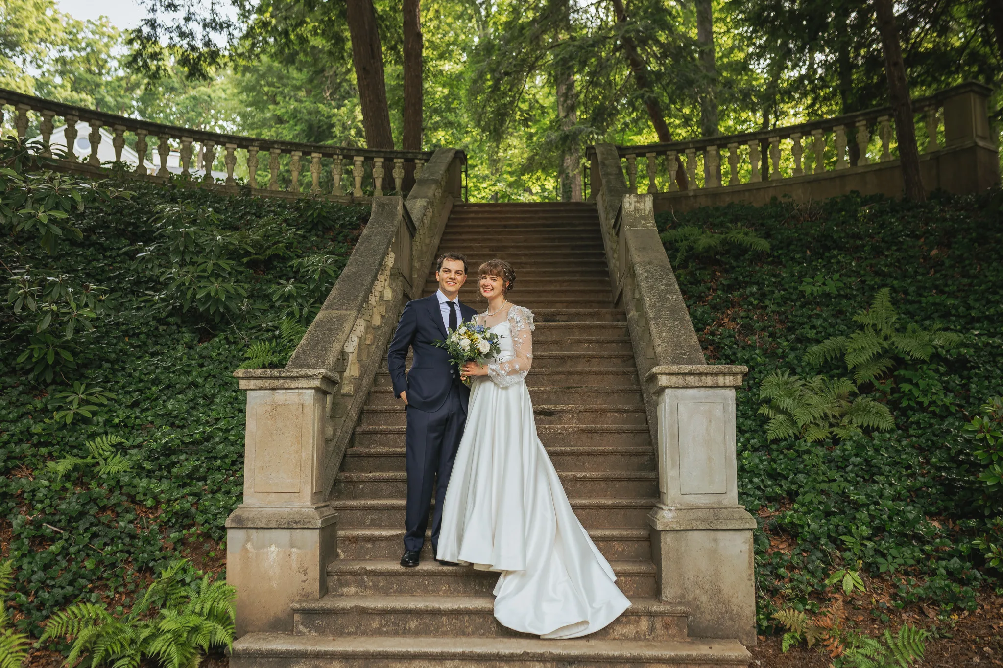 Wedding Formals: standing together on the grand staircase with her bouquet, on their wedding day at Cator Woolford Gardens in Atlanta, GA