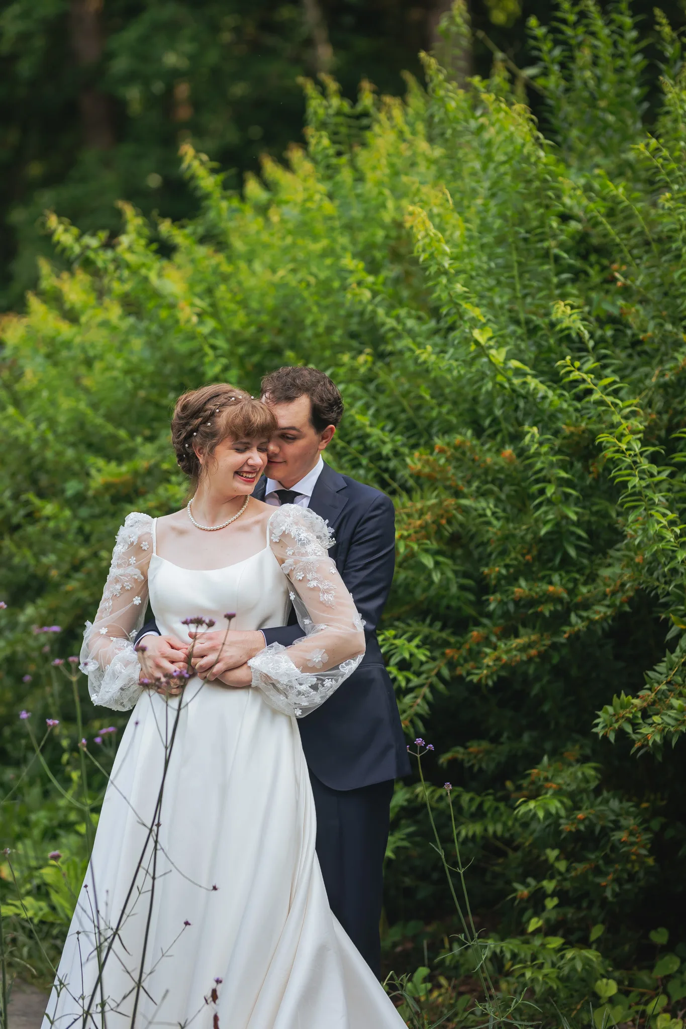 Wedding Formals: the two of them in the greenery, laughing, on their wedding day at Cator Woolford Gardens in Atlanta, GA