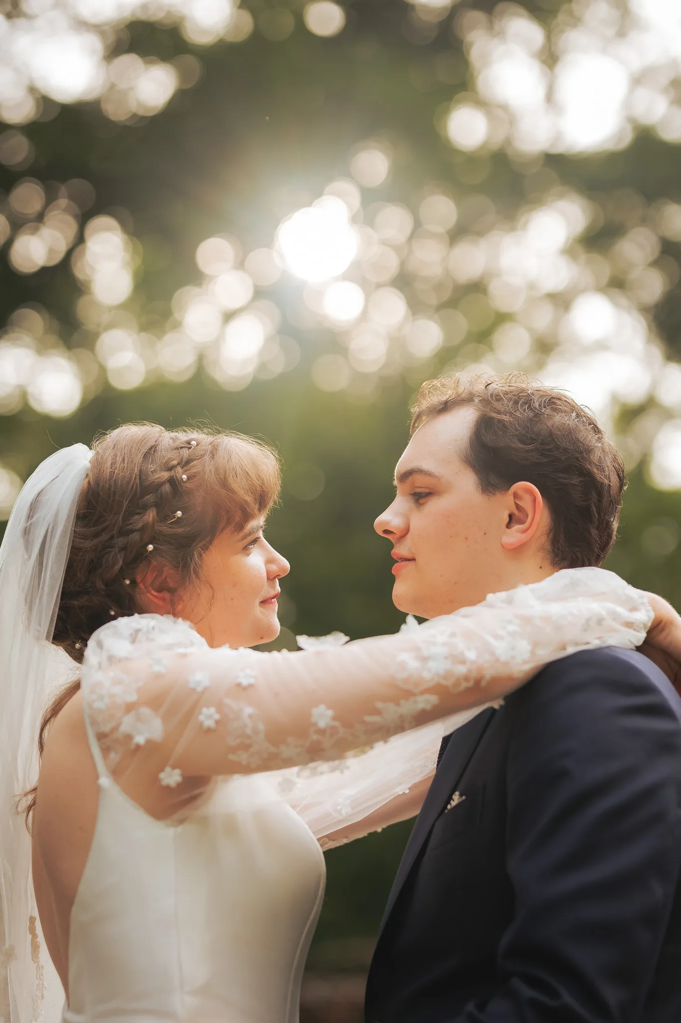 Wedding Formals: face to face with her arms around his neck, sunlight in the trees, on their wedding day at Cator Woolford Gardens in Atlanta, GA