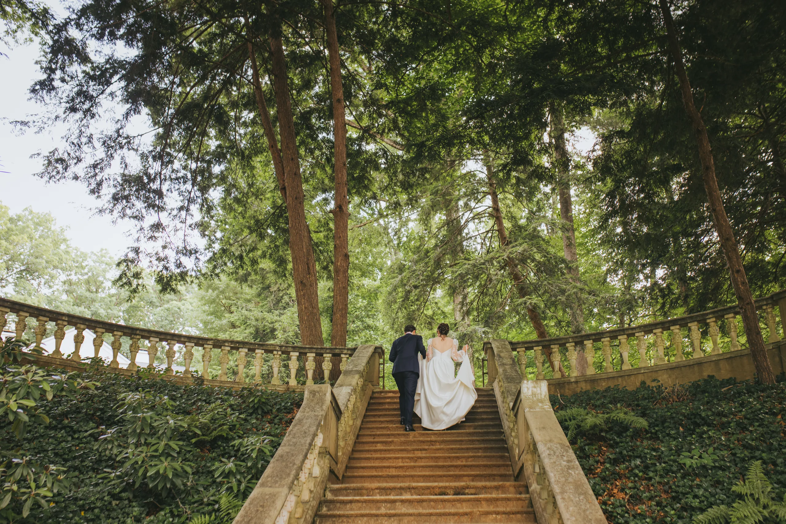 Wedding Formals: walking up the staircase toward the trees, on their wedding day at Cator Woolford Gardens in Atlanta, GA