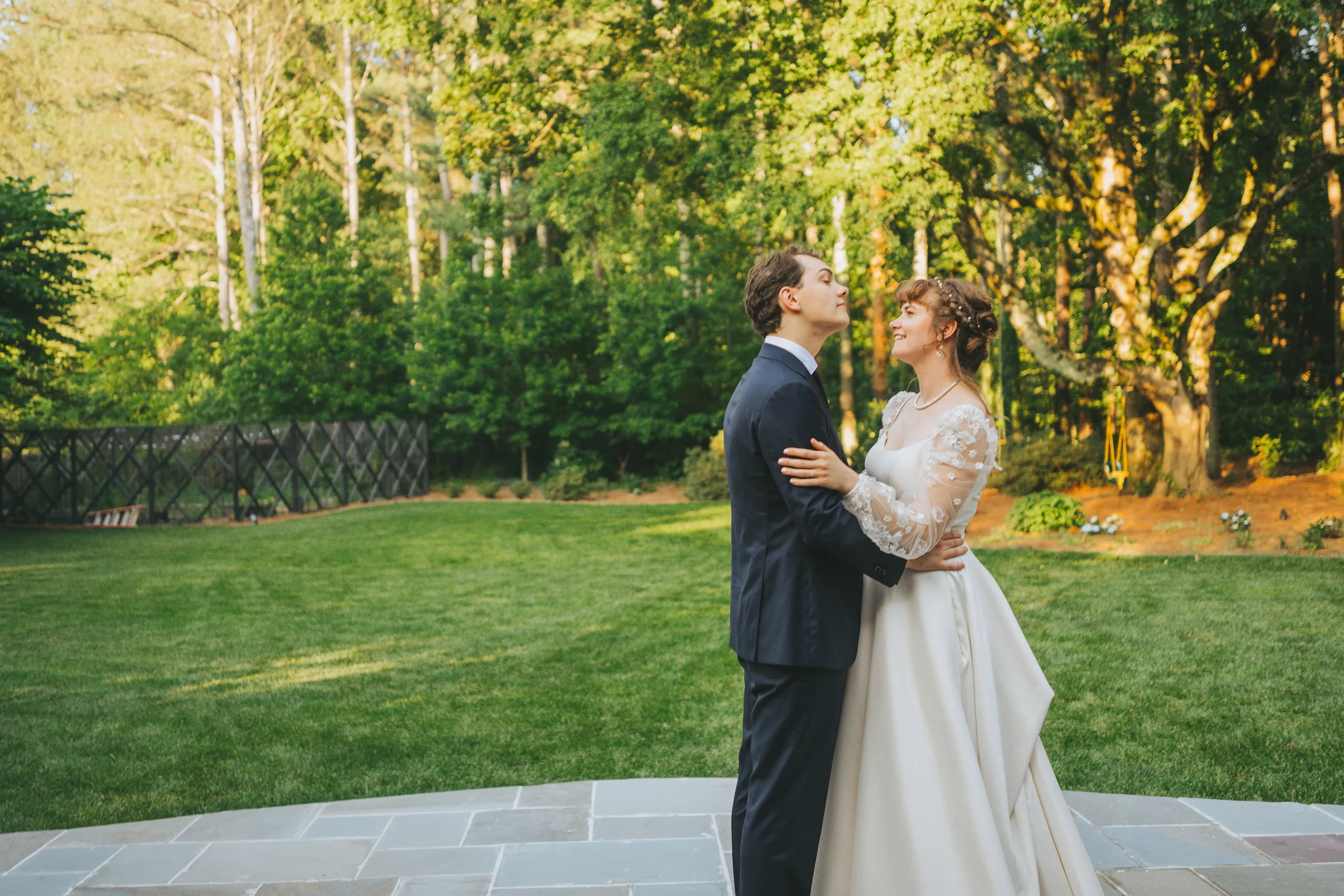 Wedding Formals: an embrace on the lawn in the evening light, at their wedding reception at a family home