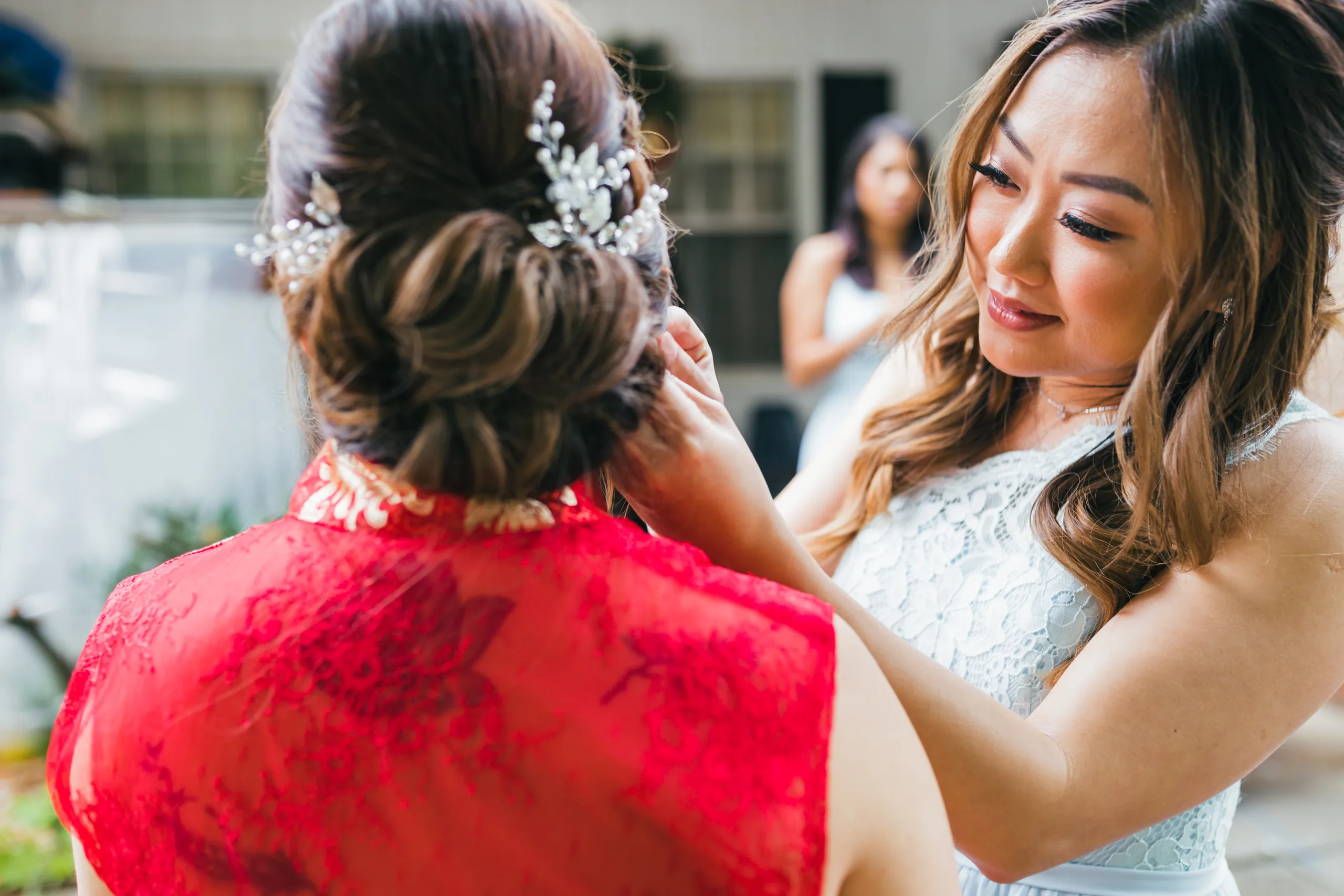 Getting Ready: a bridesmaid fixing the bride's hair comb before their wedding at the Payne-Corley House in Duluth, GA