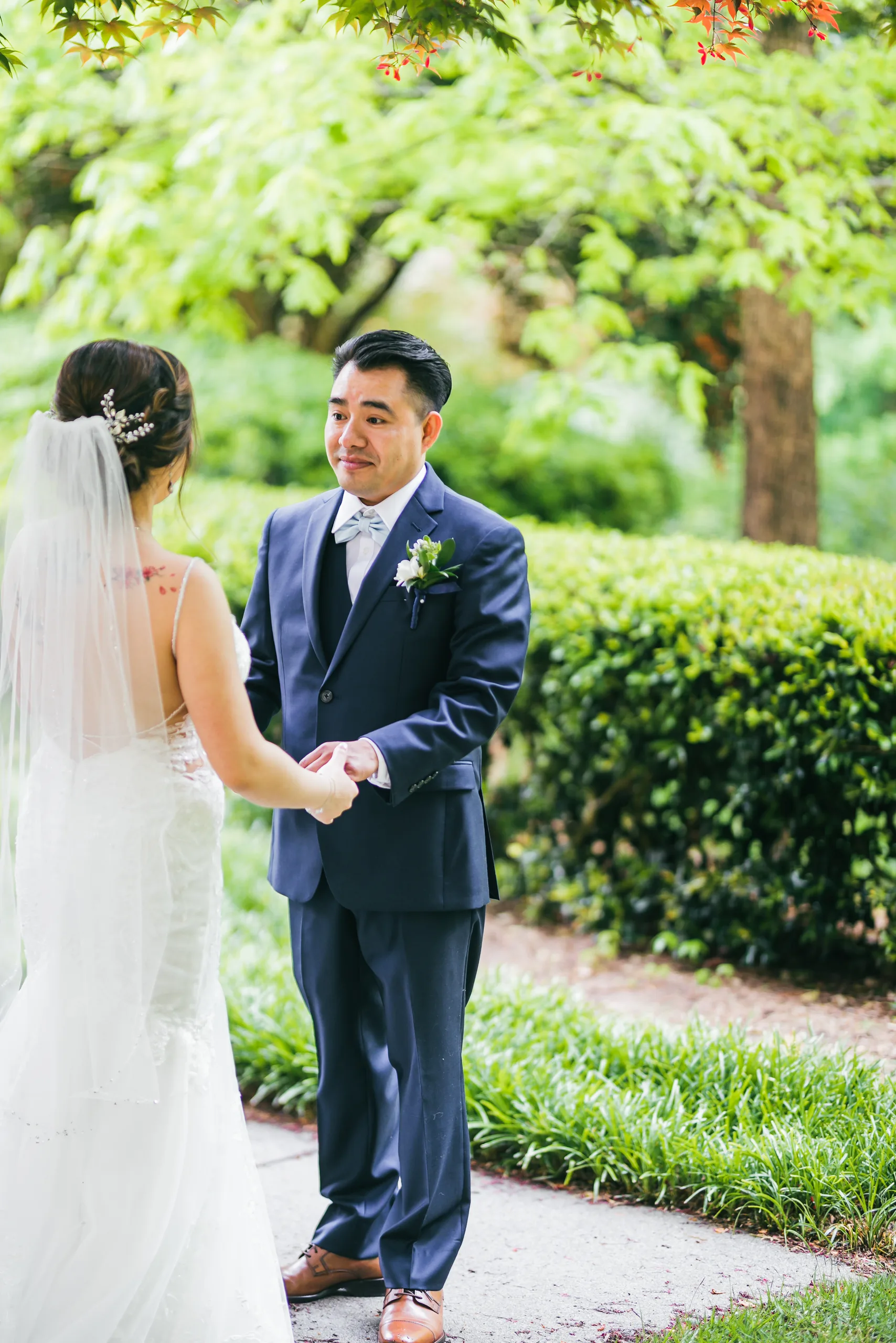 First Look: holding hands on the garden path before their wedding at Holy Cross Catholic Church in Atlanta, GA