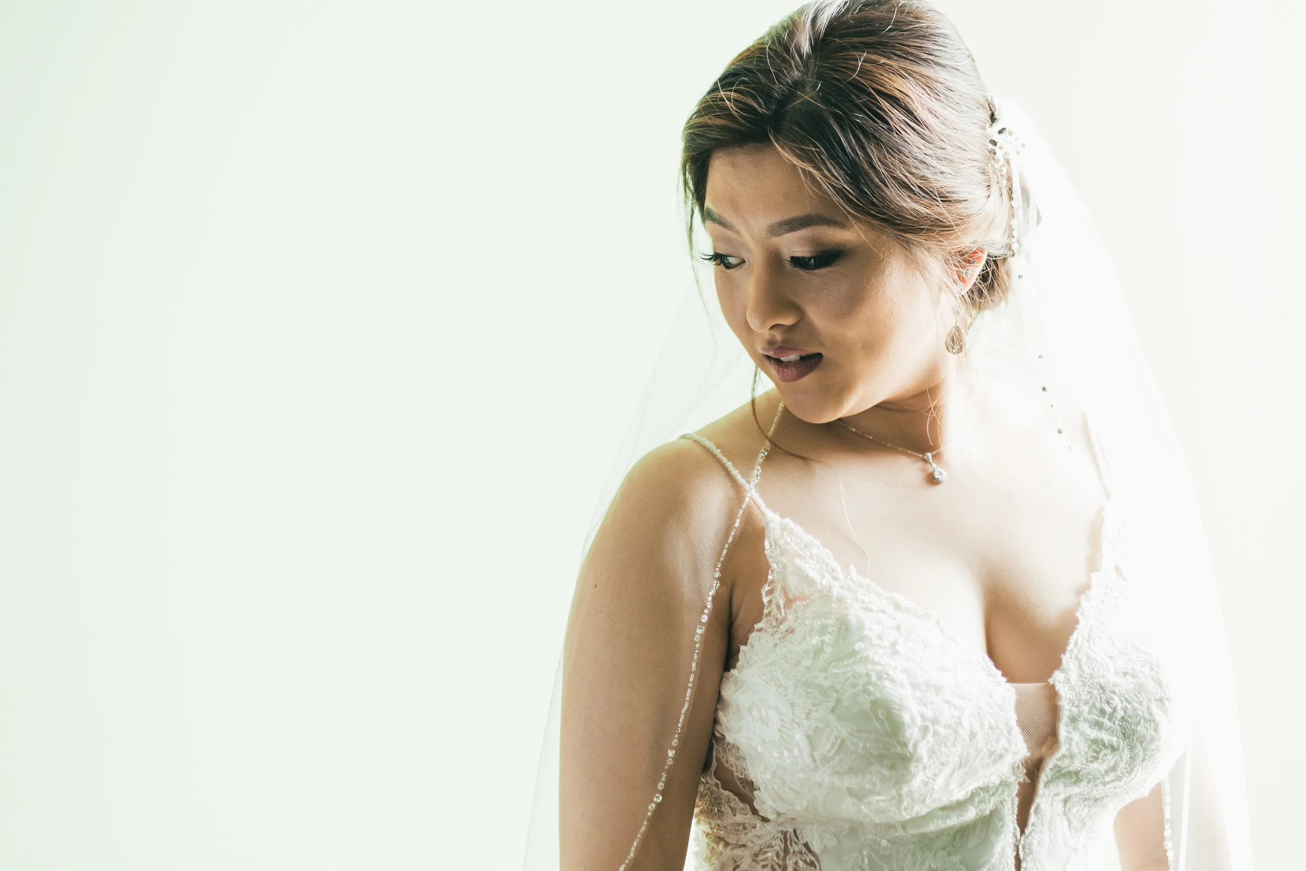 Bridal Portraits: the bride looking down in her veil before their wedding at Holy Cross Catholic Church in Atlanta, GA