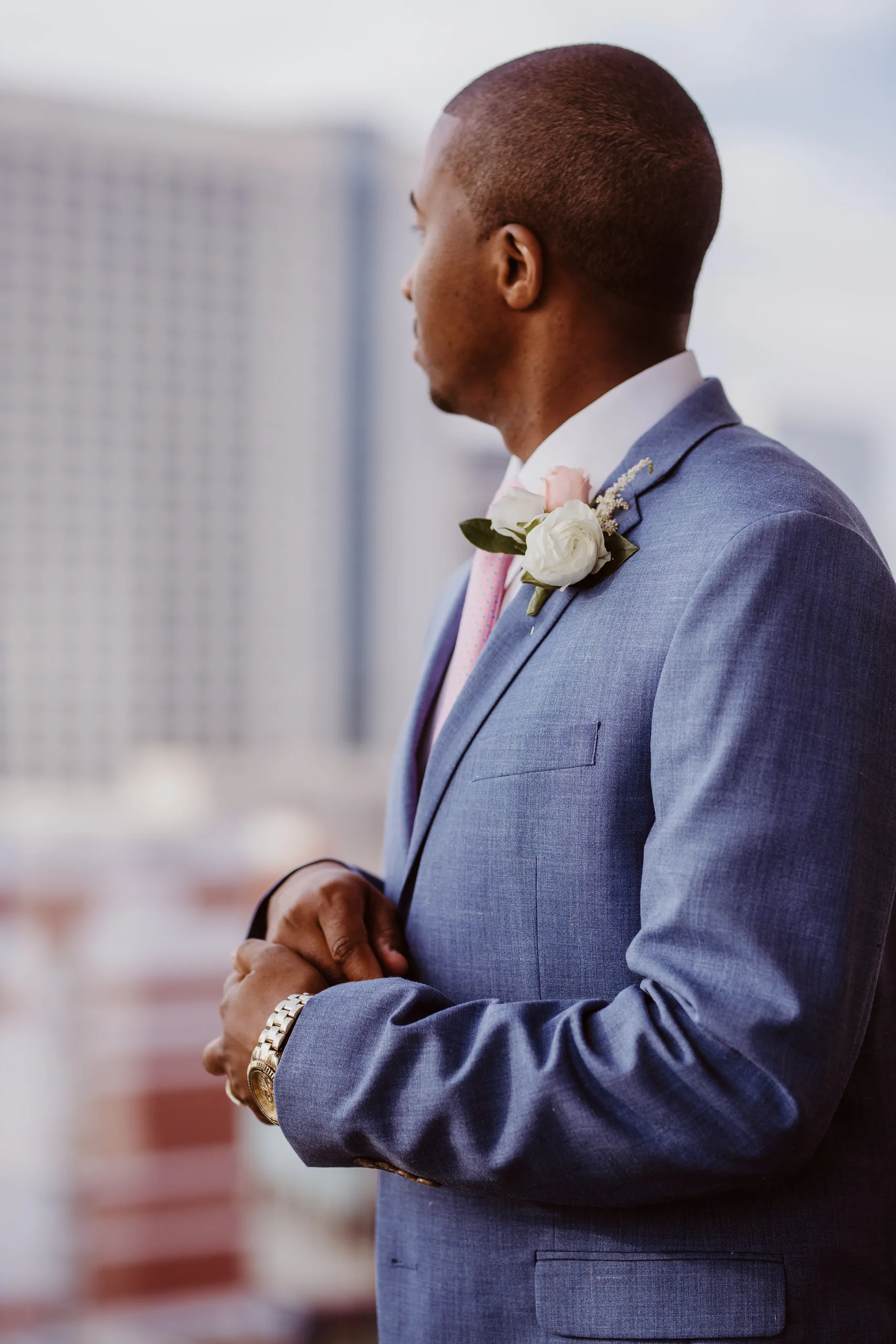 Getting Ready: the groom looking out over the city in his suit, before their elopement at Ventanas in Atlanta, GA
