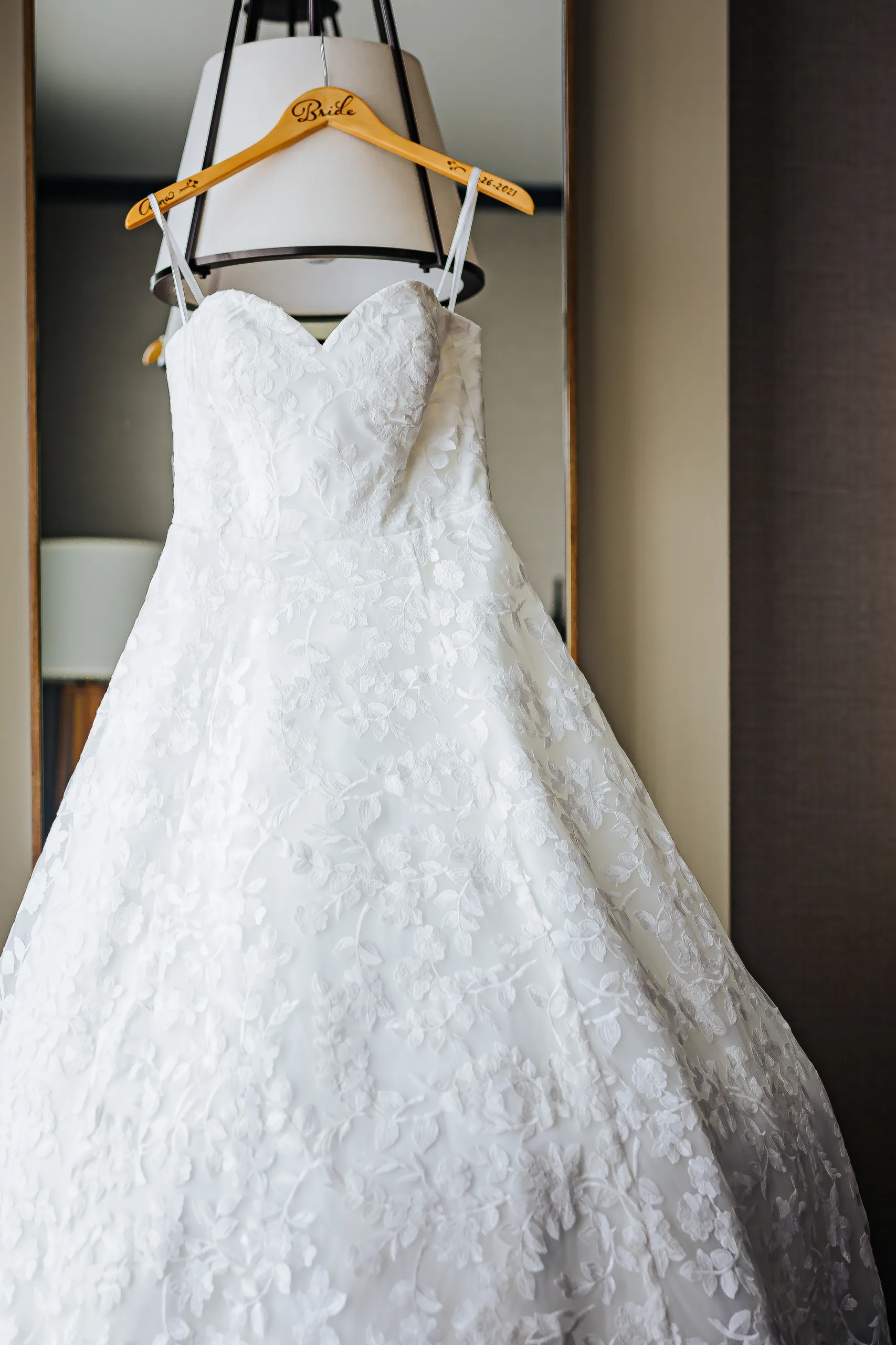 Getting Ready: her gown hanging on a Bride hanger before their wedding at the Omni Hotel at The Battery in Atlanta, GA