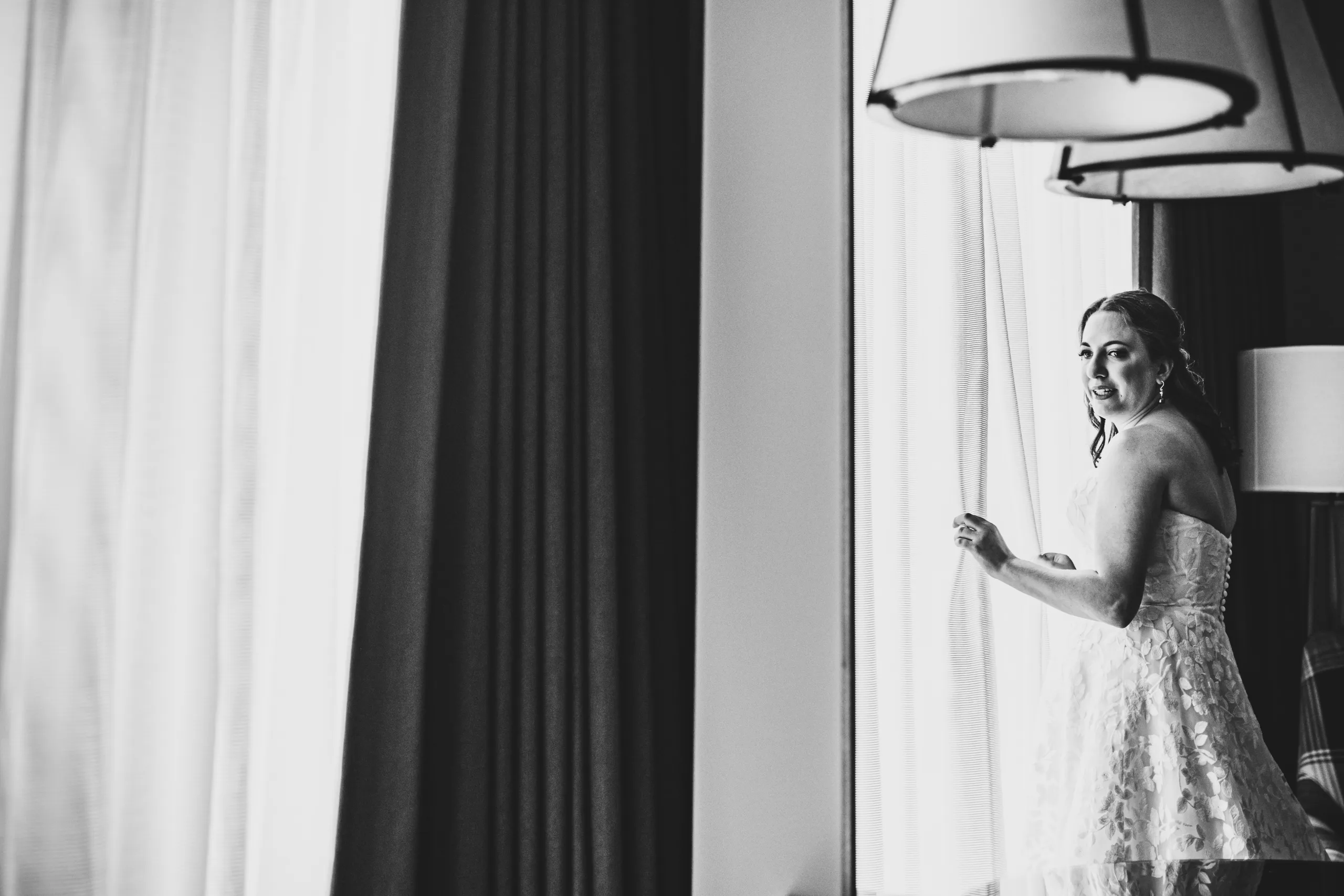 Getting Ready: the bride by the window in the morning light before their wedding at the Omni Hotel at The Battery in Atlanta, GA