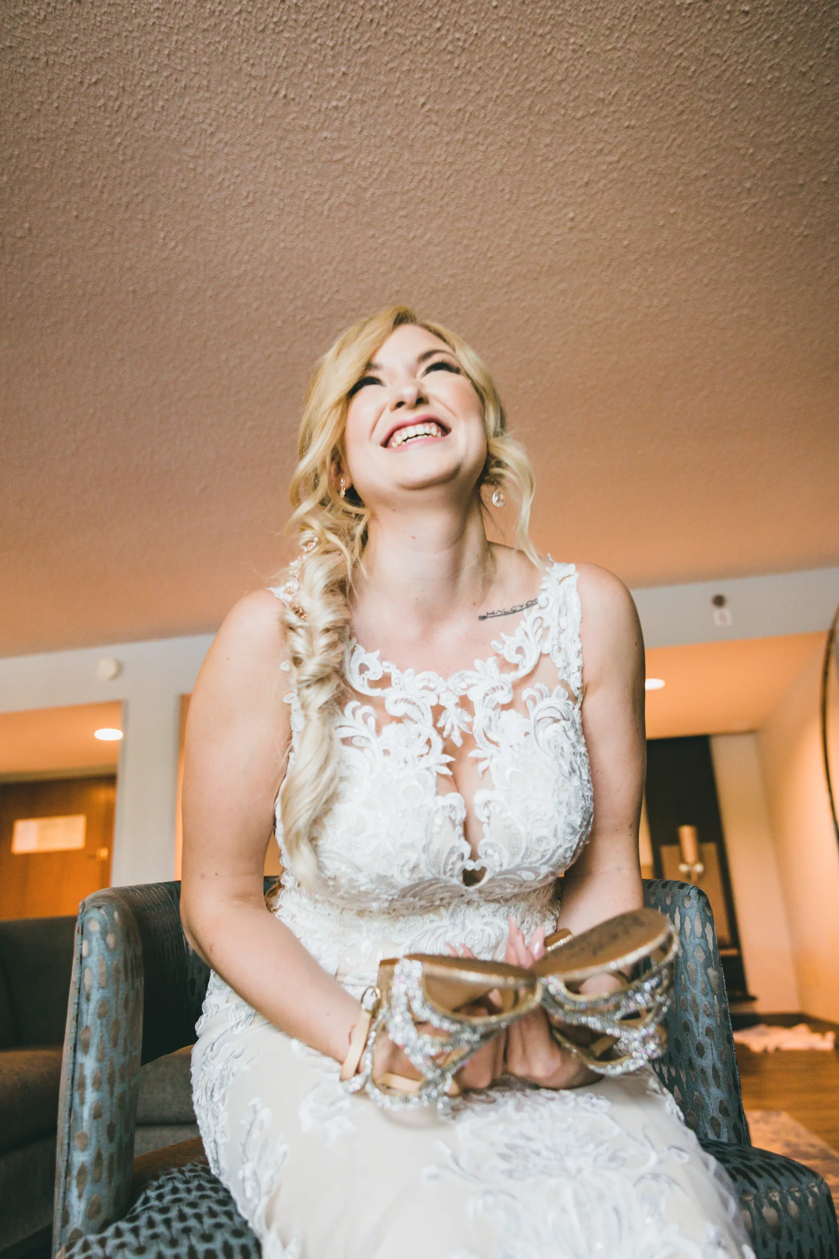 Getting Ready: the bride laughing as she holds her sparkly heels, before their wedding at Atlanta Evergreen Lakeside Resort in Stone Mountain, GA