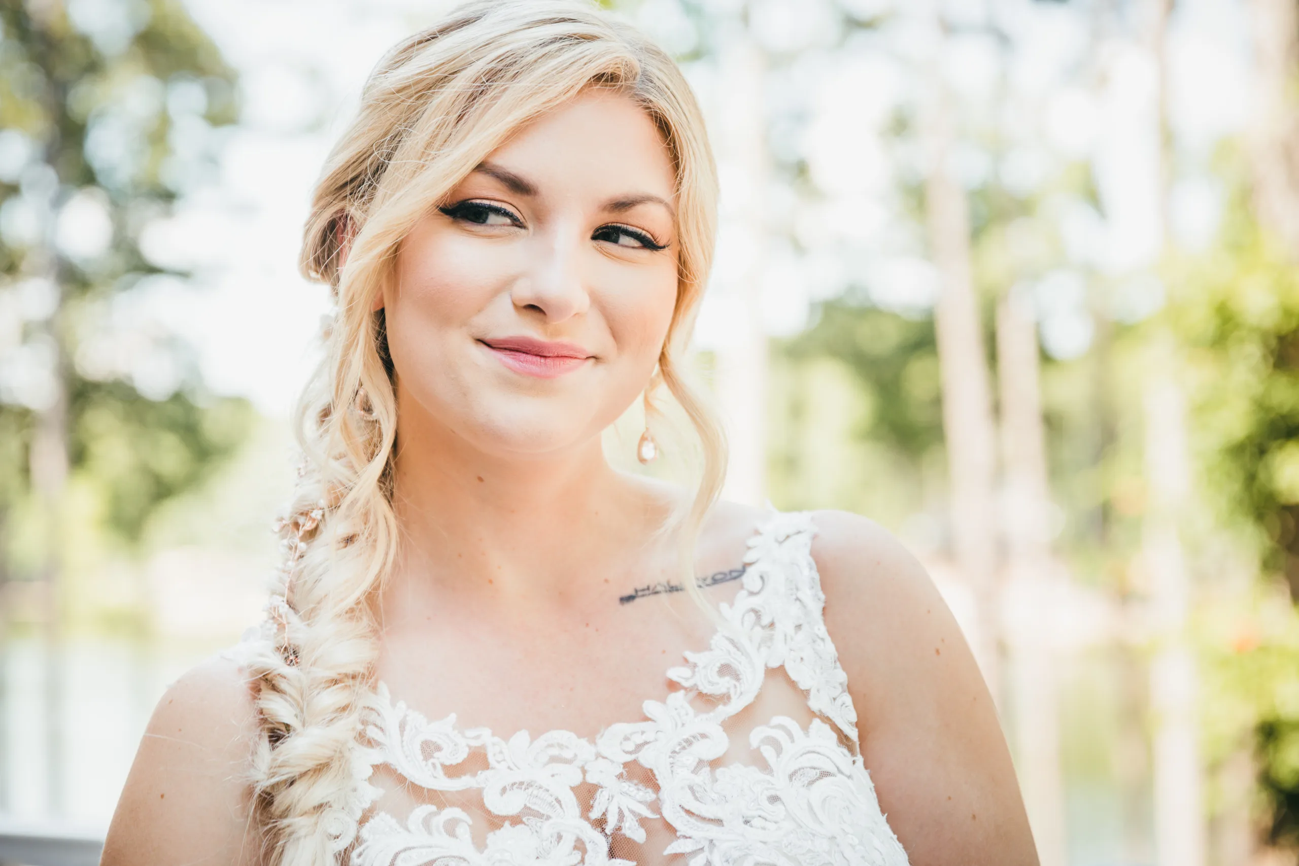 Bridal Portraits: the bride with the lake blurred behind her, before their wedding at Atlanta Evergreen Lakeside Resort in Stone Mountain, GA