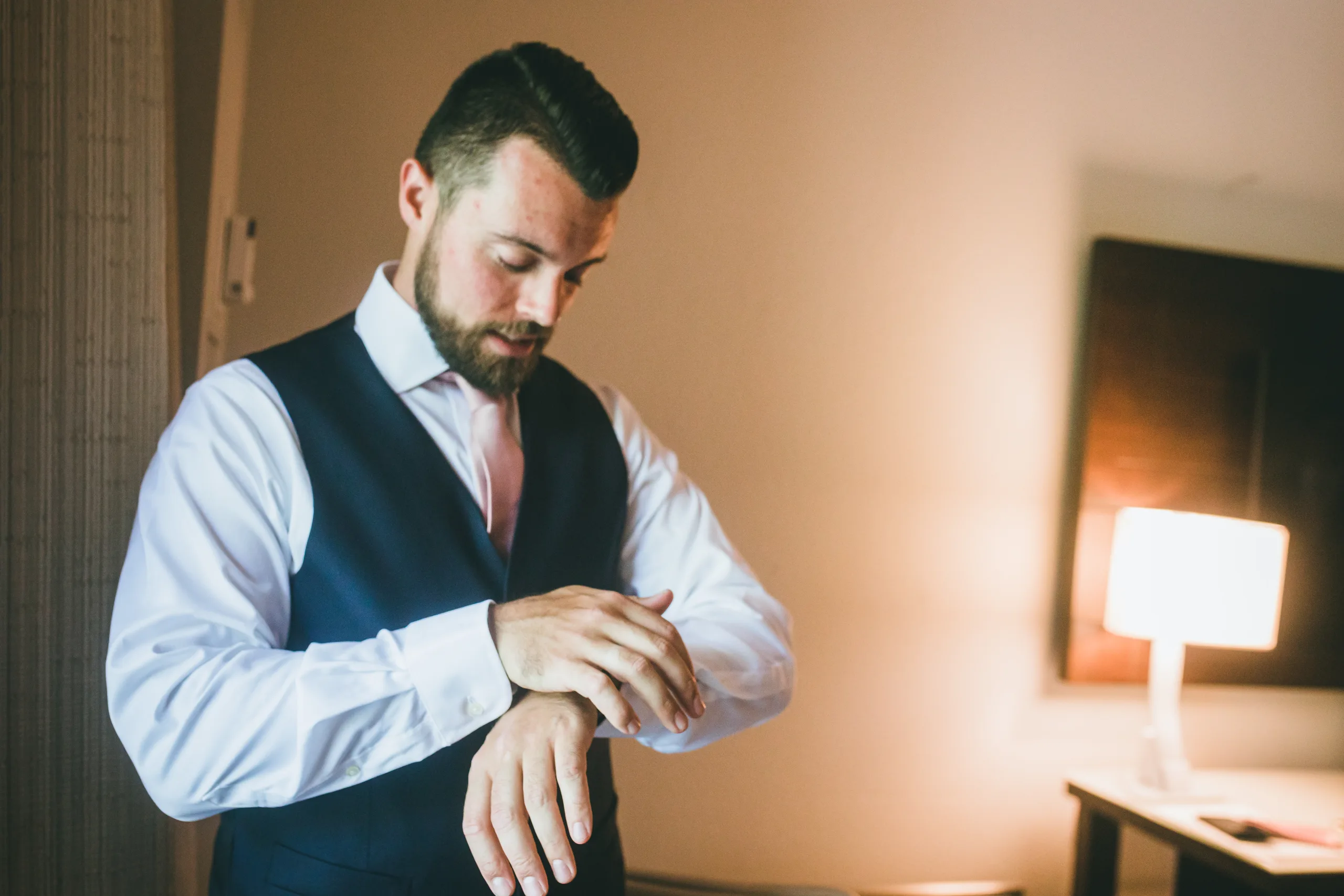 Getting Ready: the groom fastening his watch, before their wedding at Atlanta Evergreen Lakeside Resort in Stone Mountain, GA