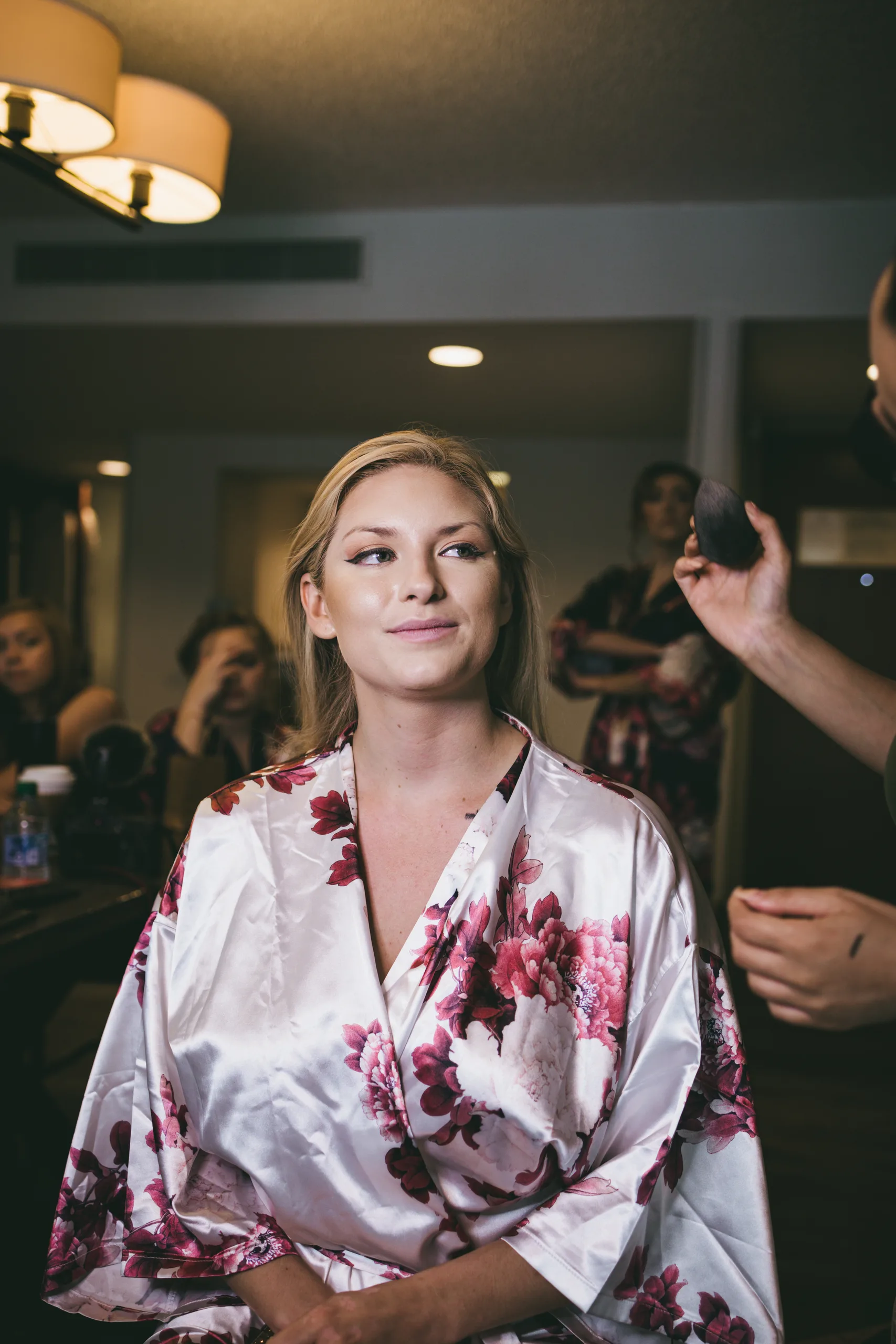 Getting Ready: the bride in her robe having her makeup finished, before their wedding at Atlanta Evergreen Lakeside Resort in Stone Mountain, GA