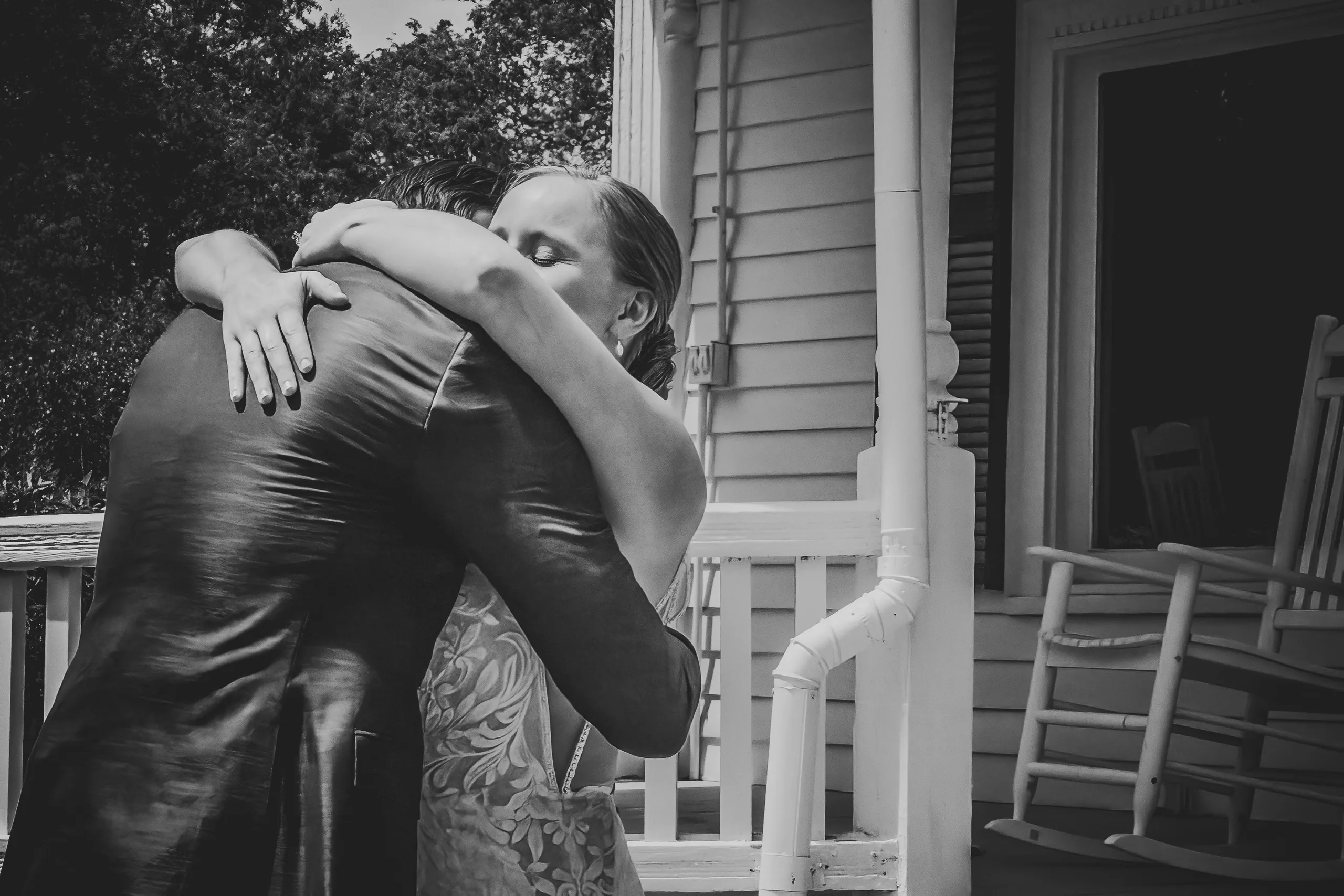 First Look: a big hug on the porch, in black and white, before their wedding at The Wildflower 301 in Greensboro, GA