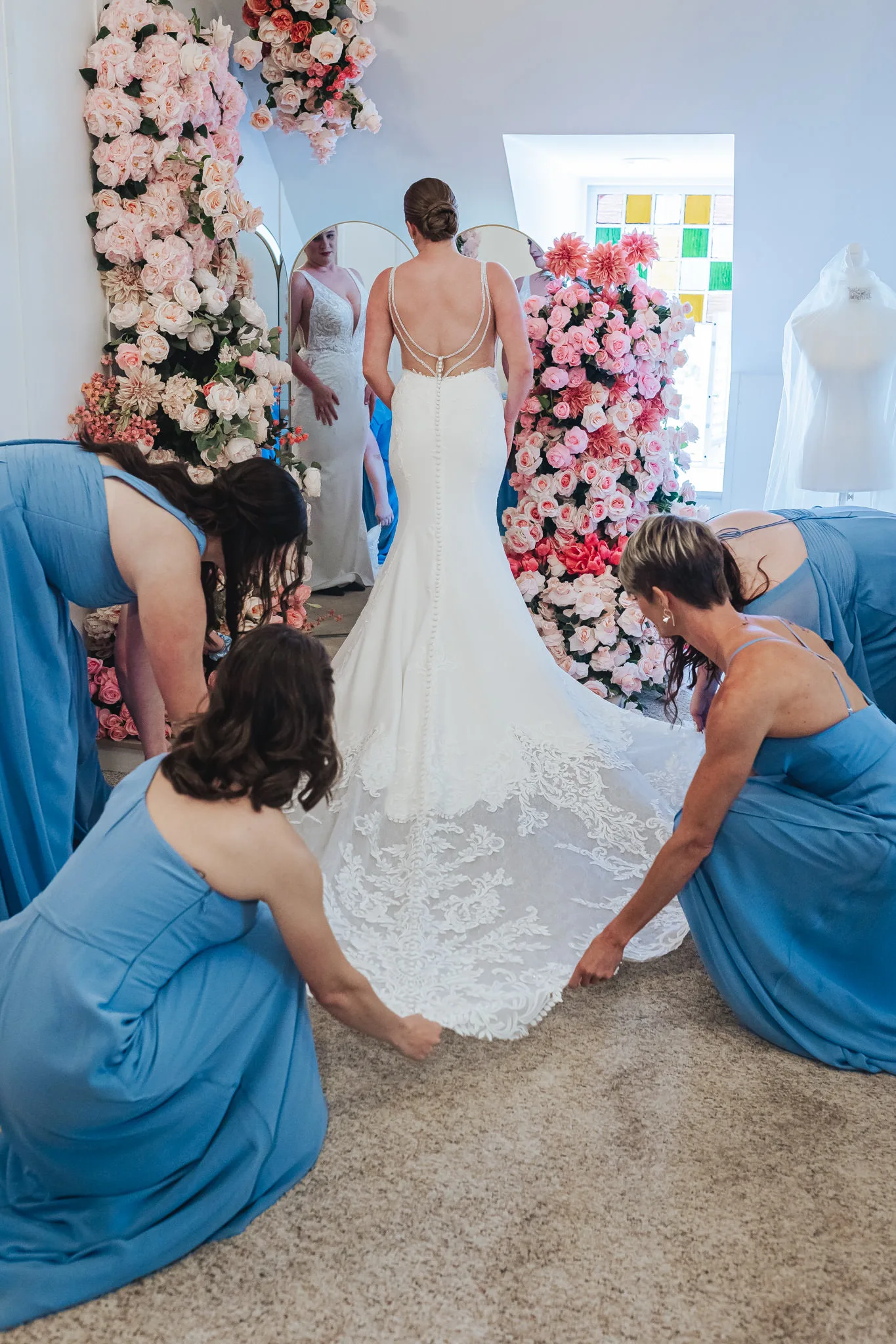 Getting Ready: her bridesmaids fixing her train, before their wedding at The Wildflower 301 in Greensboro, GA