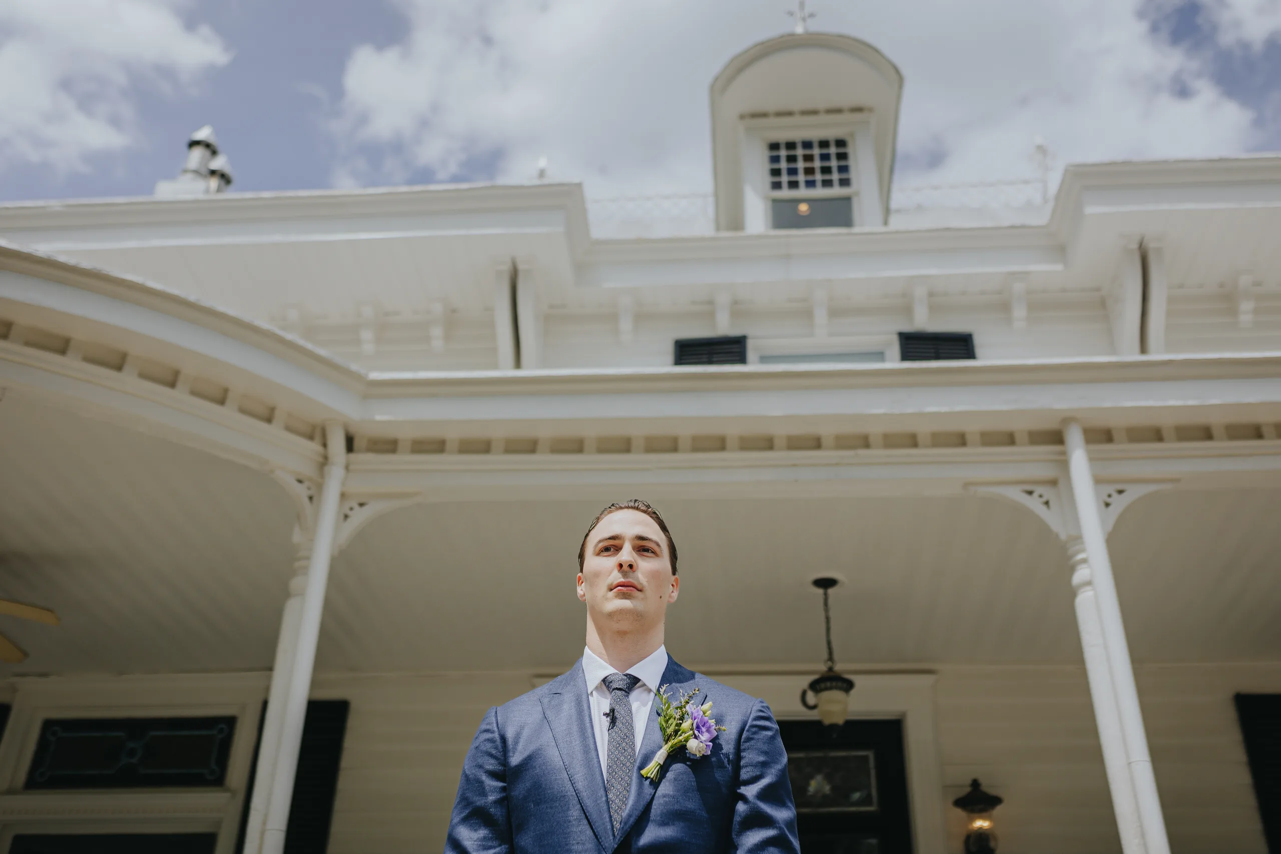 First Look: the groom waiting in front of the mansion, before their wedding at The Wildflower 301 in Greensboro, GA