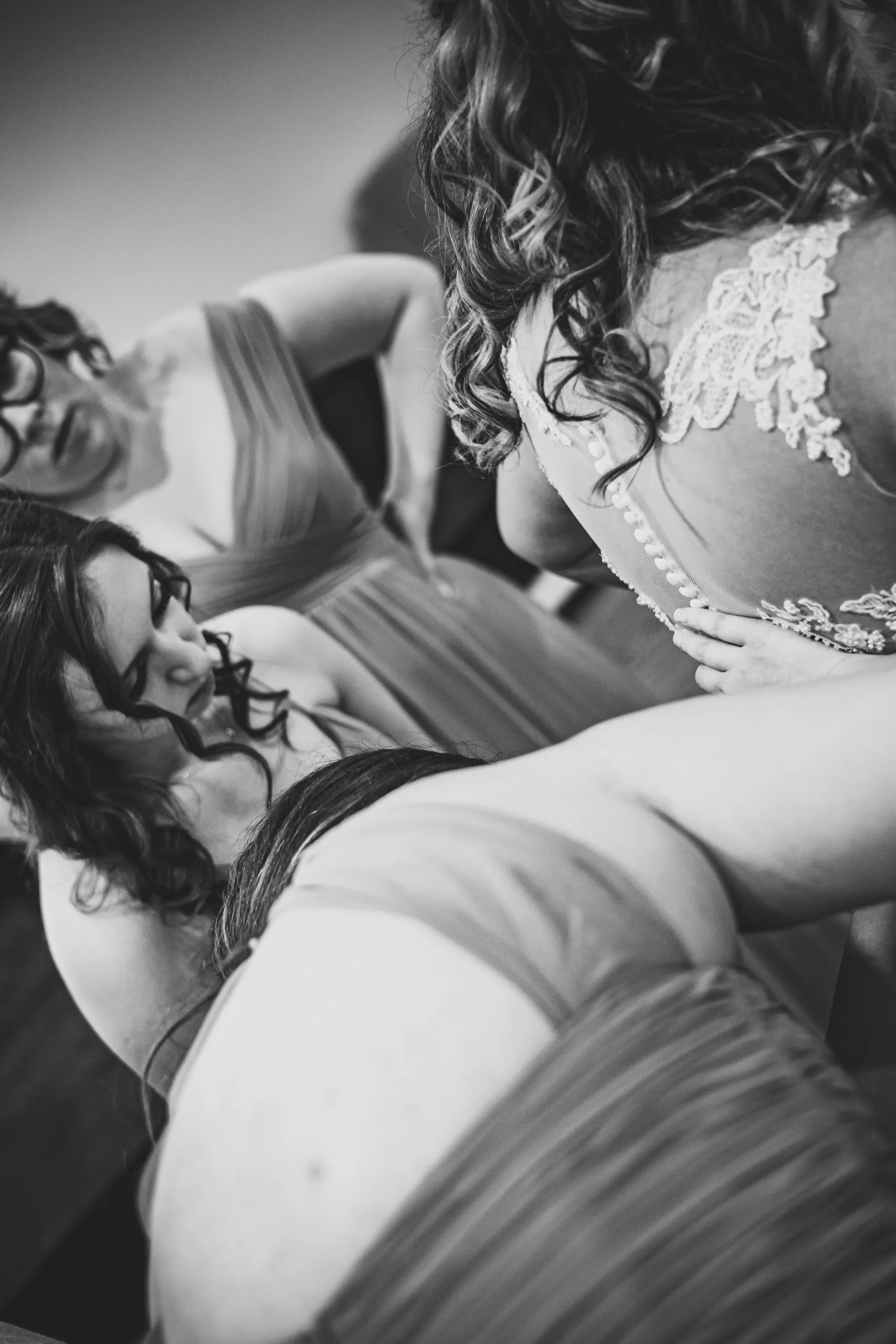 Getting Ready: bridesmaids helping with her gown from behind, in black and white before their wedding at the Country Club of Roswell in Roswell, GA
