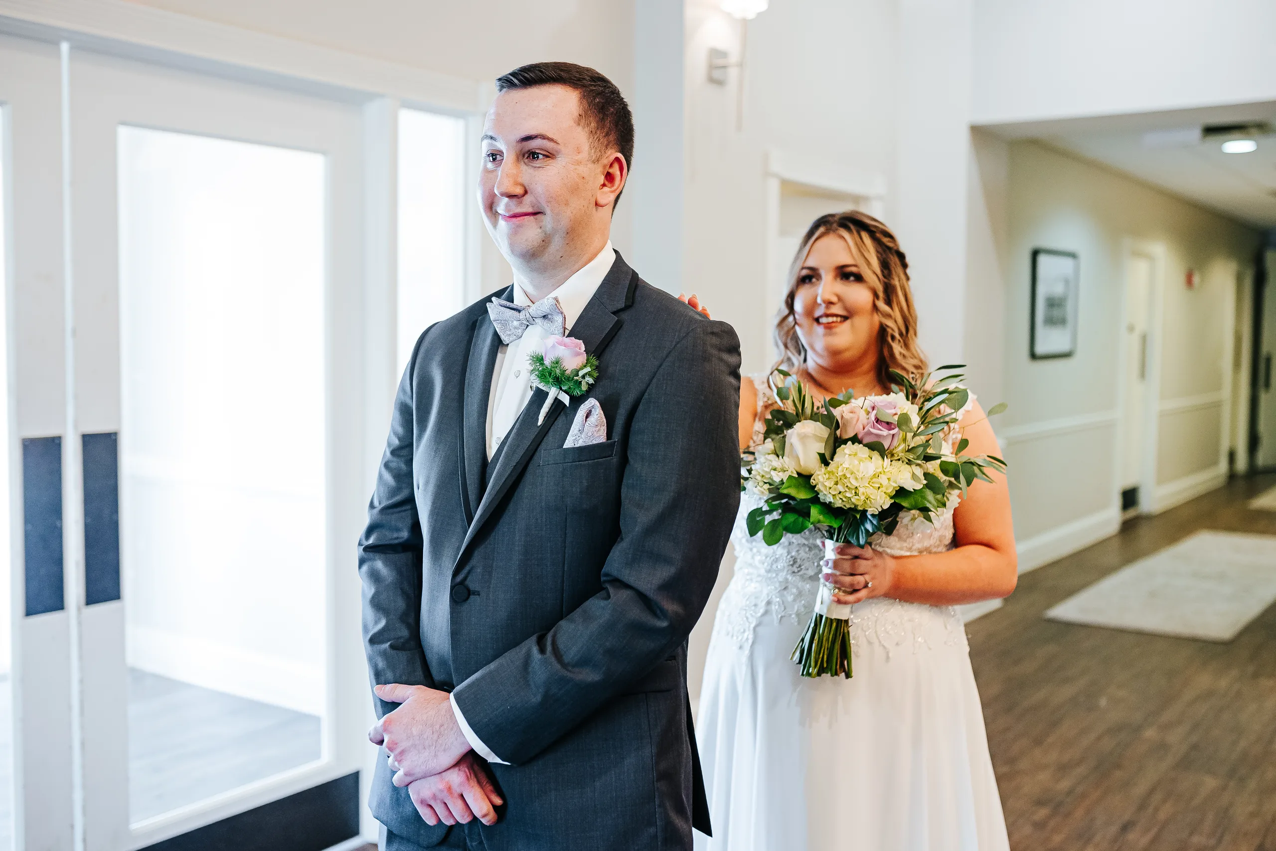 First Look: the groom waiting as she walks up behind him before their wedding at the Country Club of Roswell in Roswell, GA